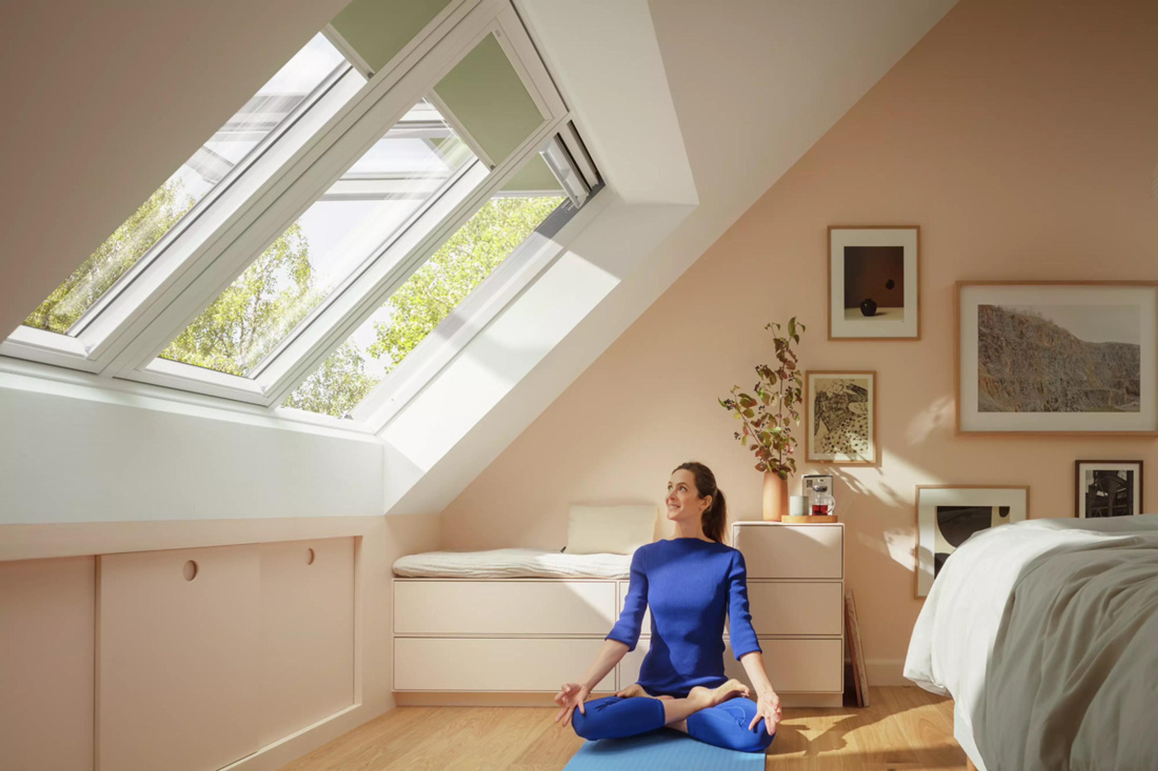 En dame som gjør yoga under takvinduet fra Velux