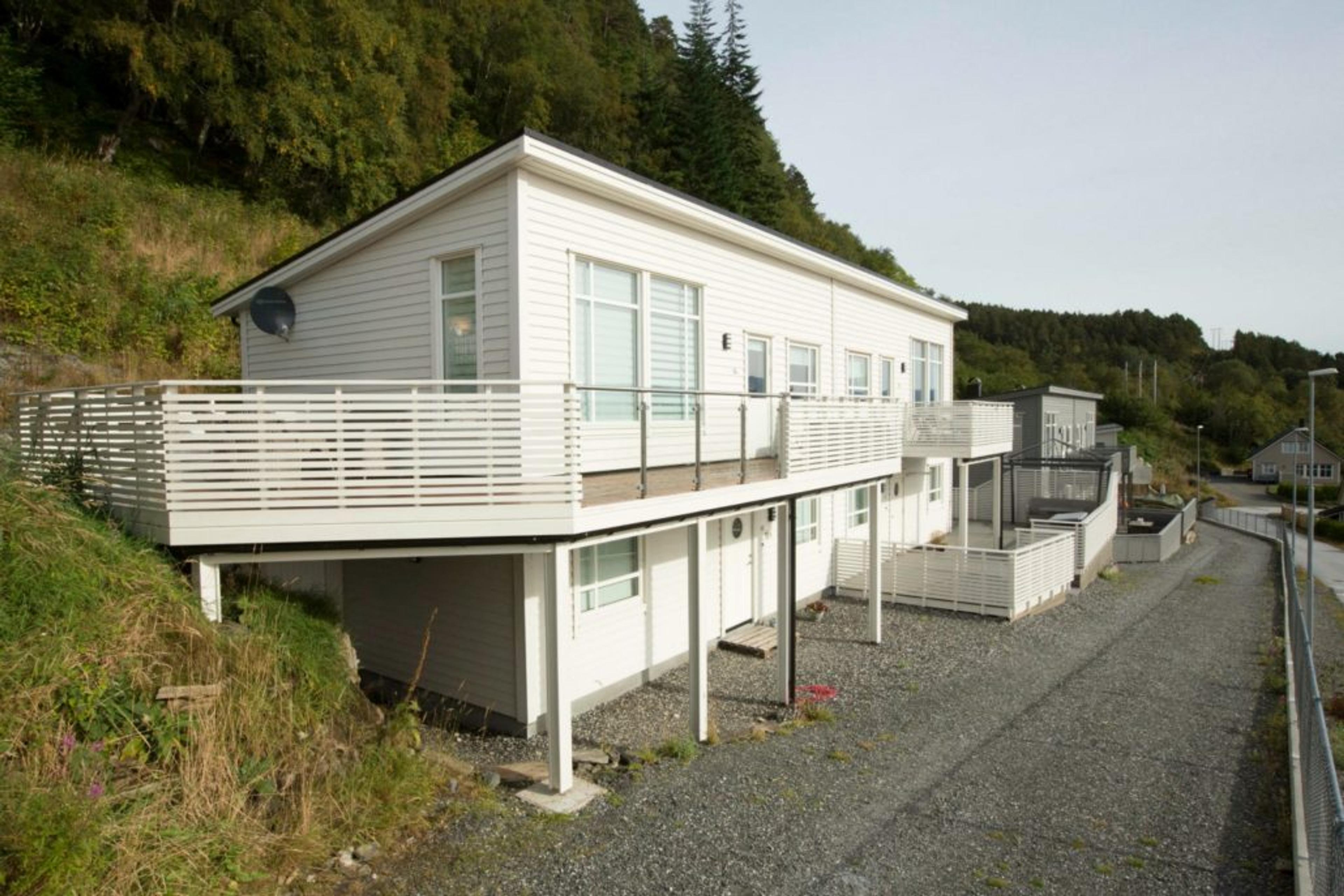 Hvit enebolig på to plan med veranda