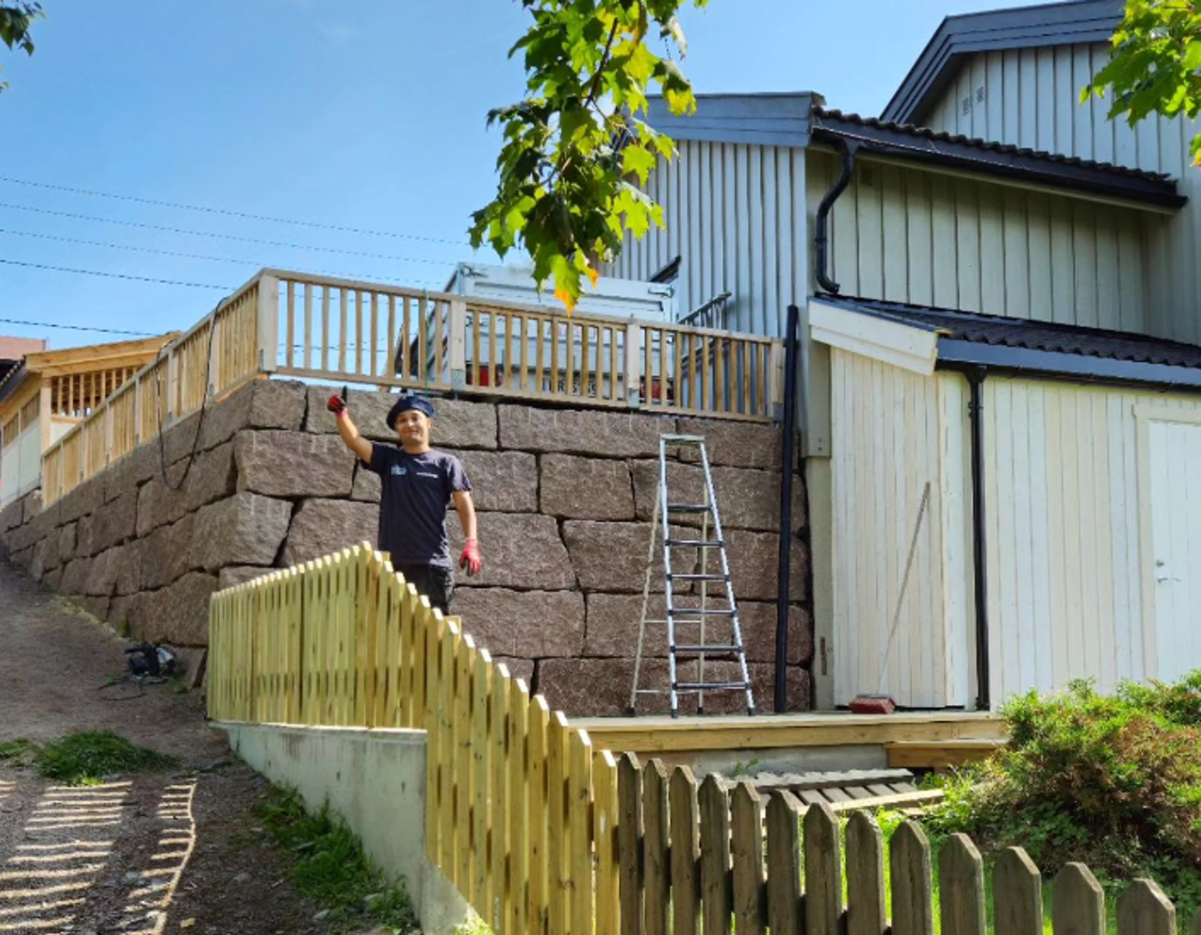 Arbeider fra Kristiansen og Stensrud AS som vinker foran nytt gjerdet