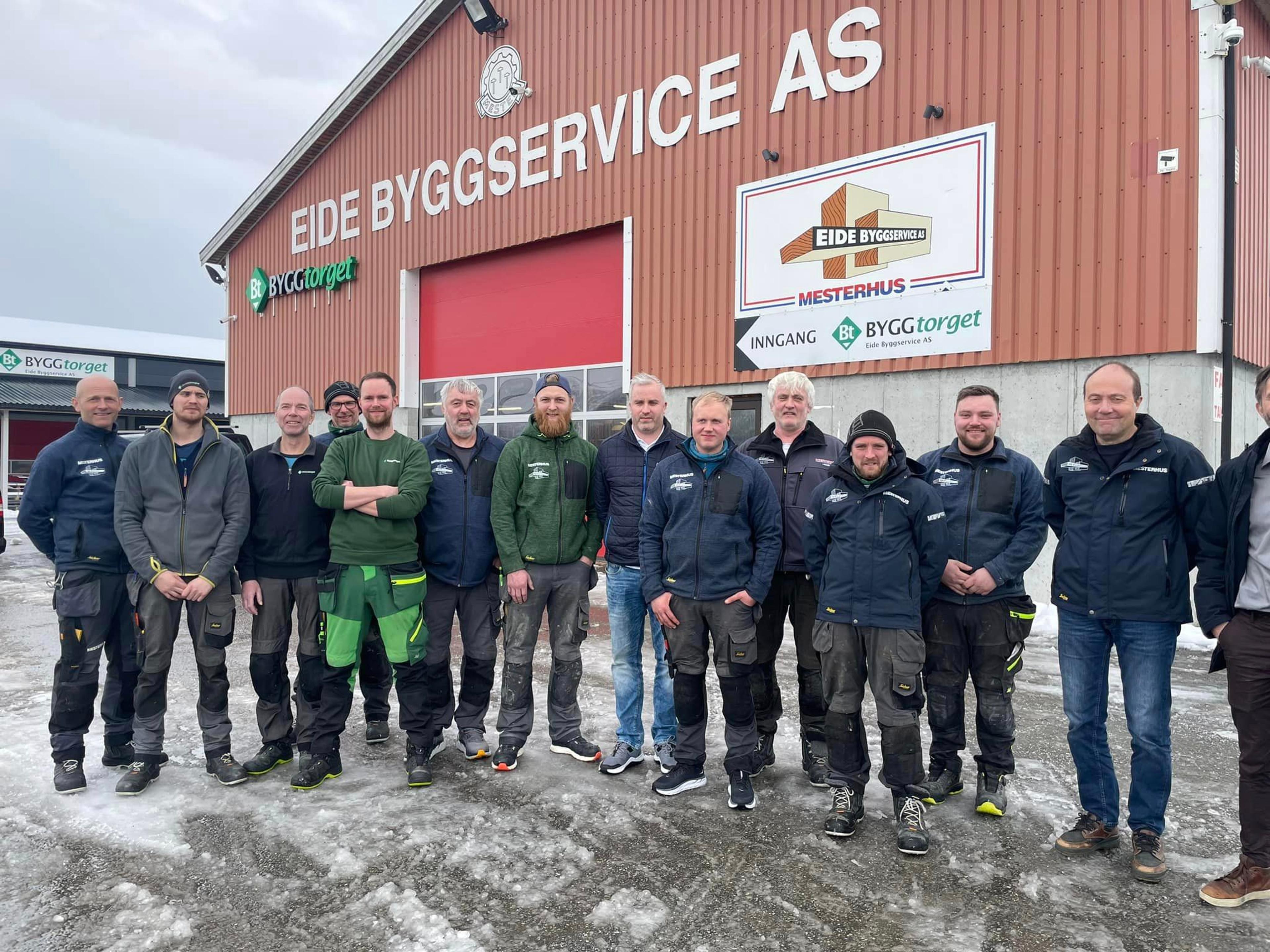Ansatte gruppebilde utenfor firmabygg