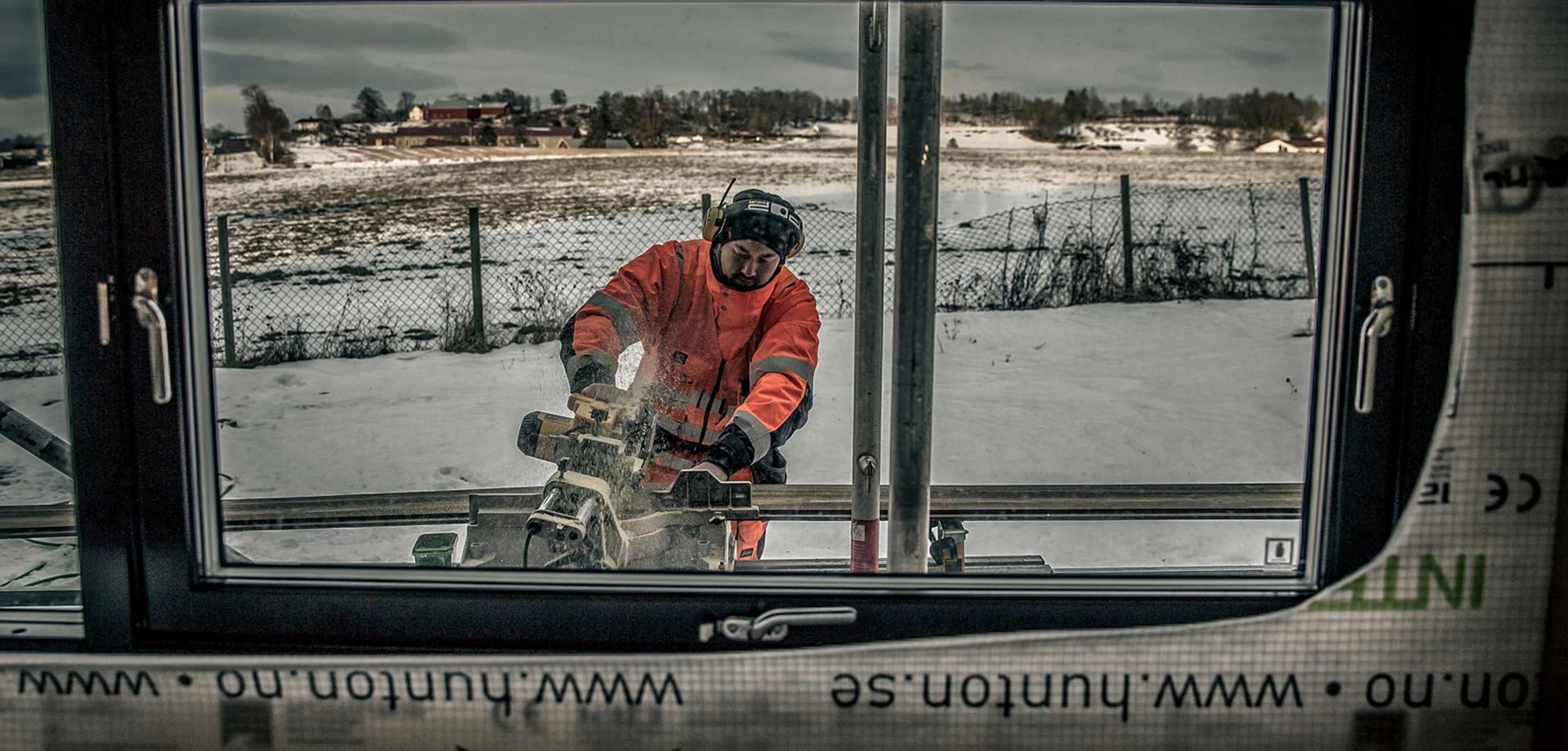 Arbeider som står ute og bruker elektronisk sag