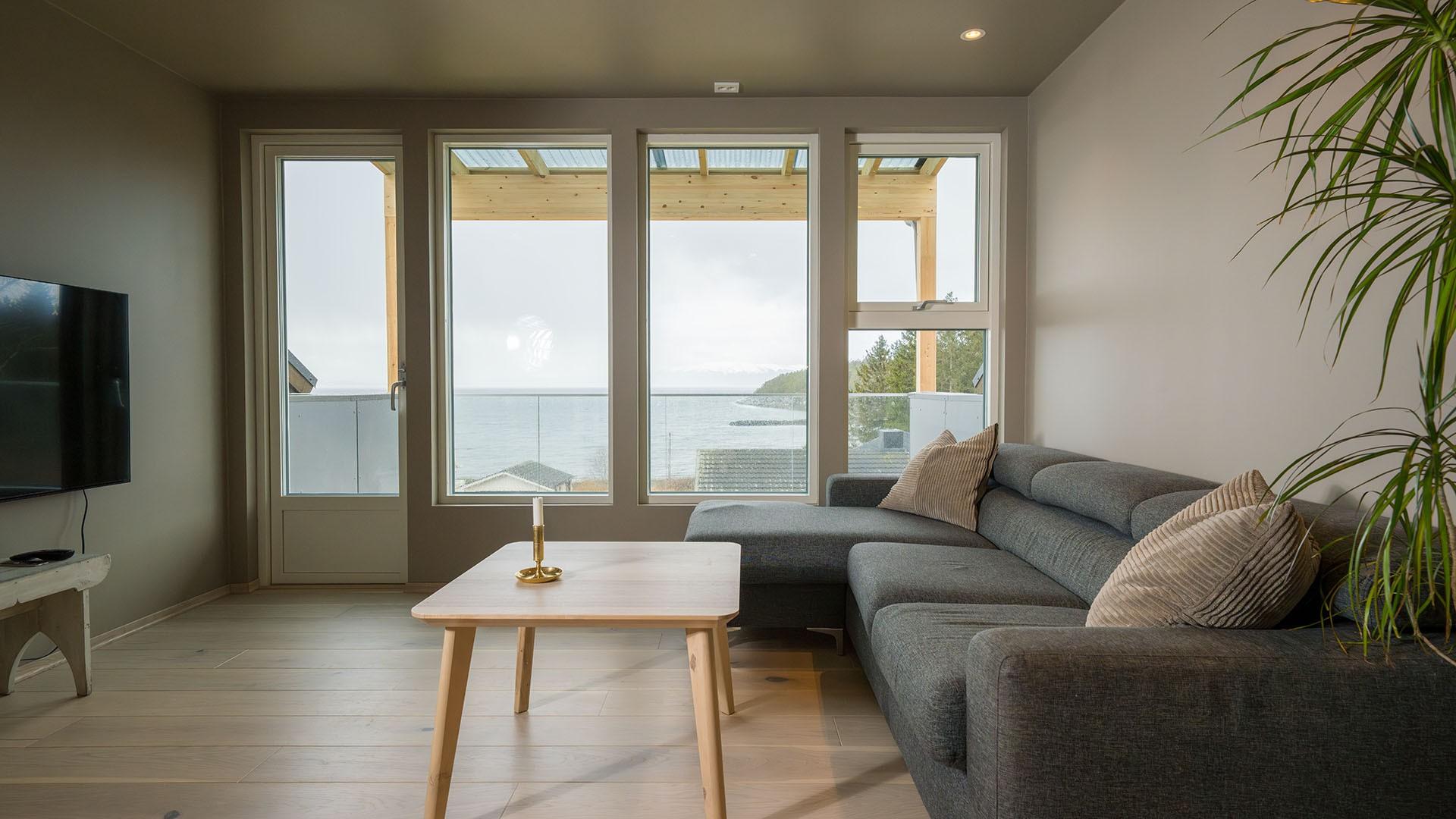 En stue med fire vinduer ut mot havet