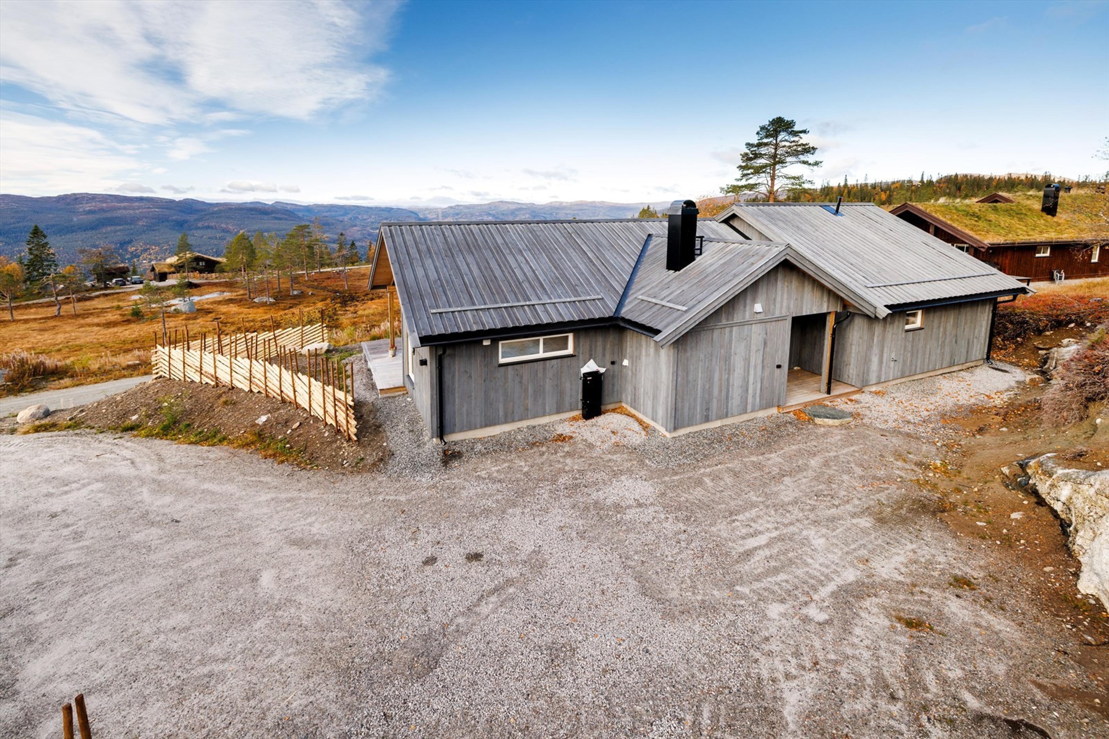 Grå hytte med gjerdet og utsikt