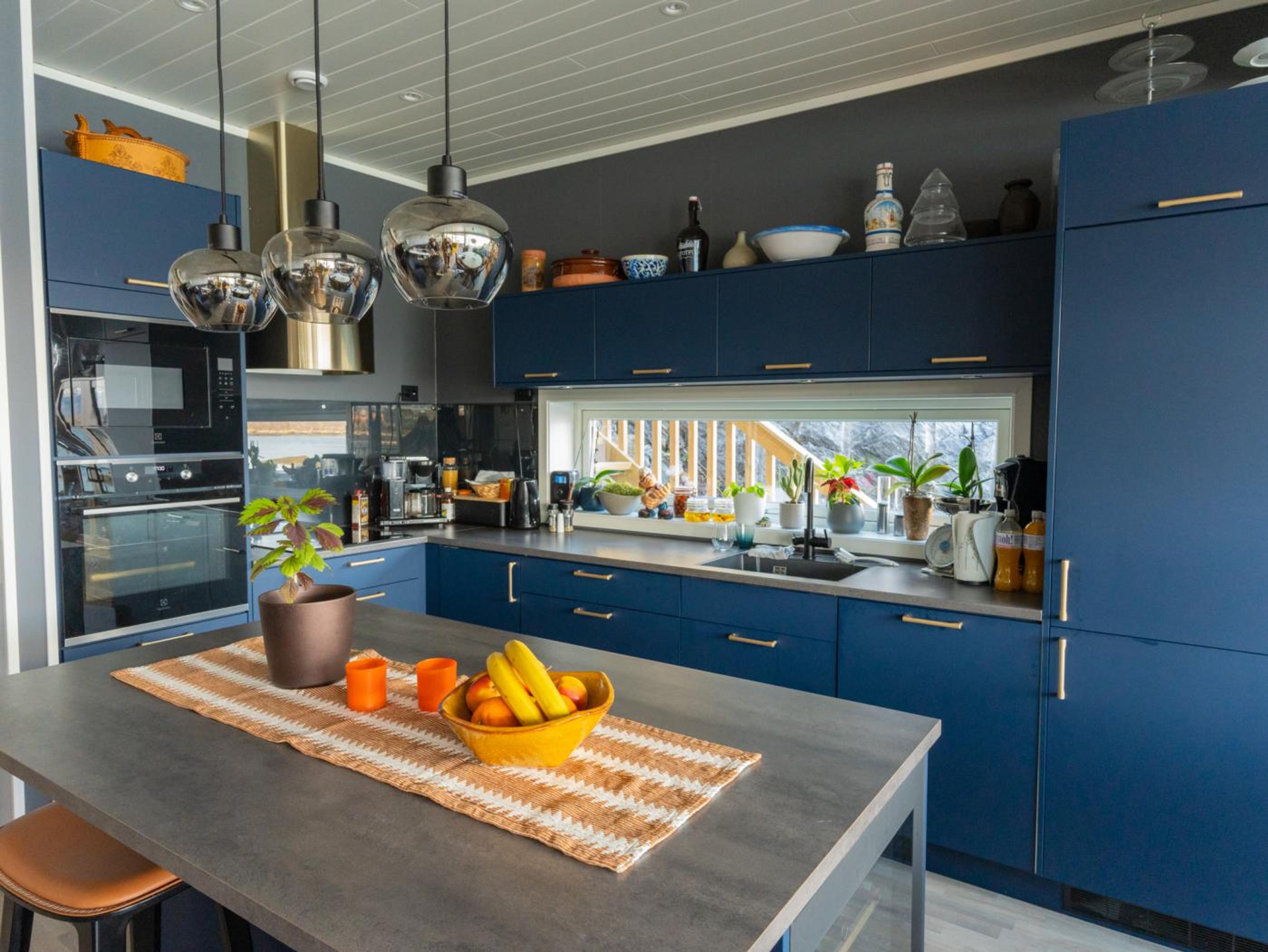 Et blått kjøkken med gull håndtak