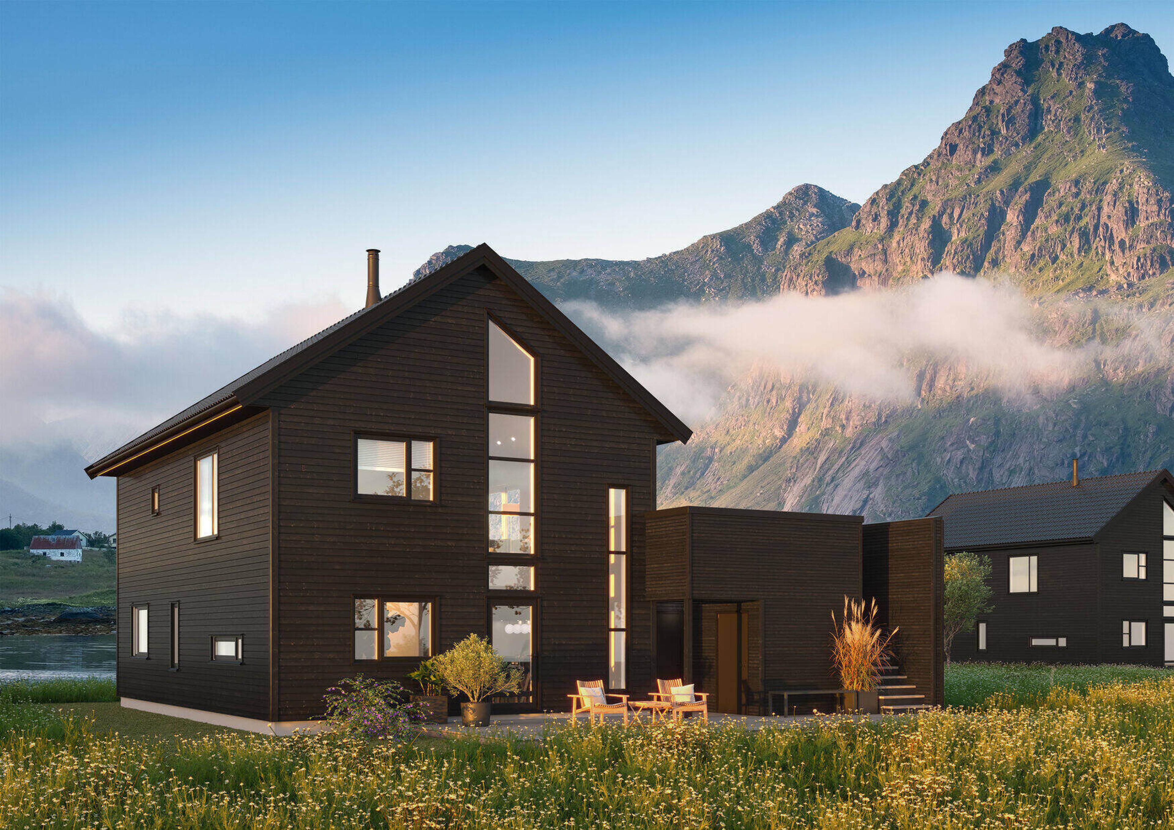 Svart enebolig over tre etasjer med fjell i bakgrunnen