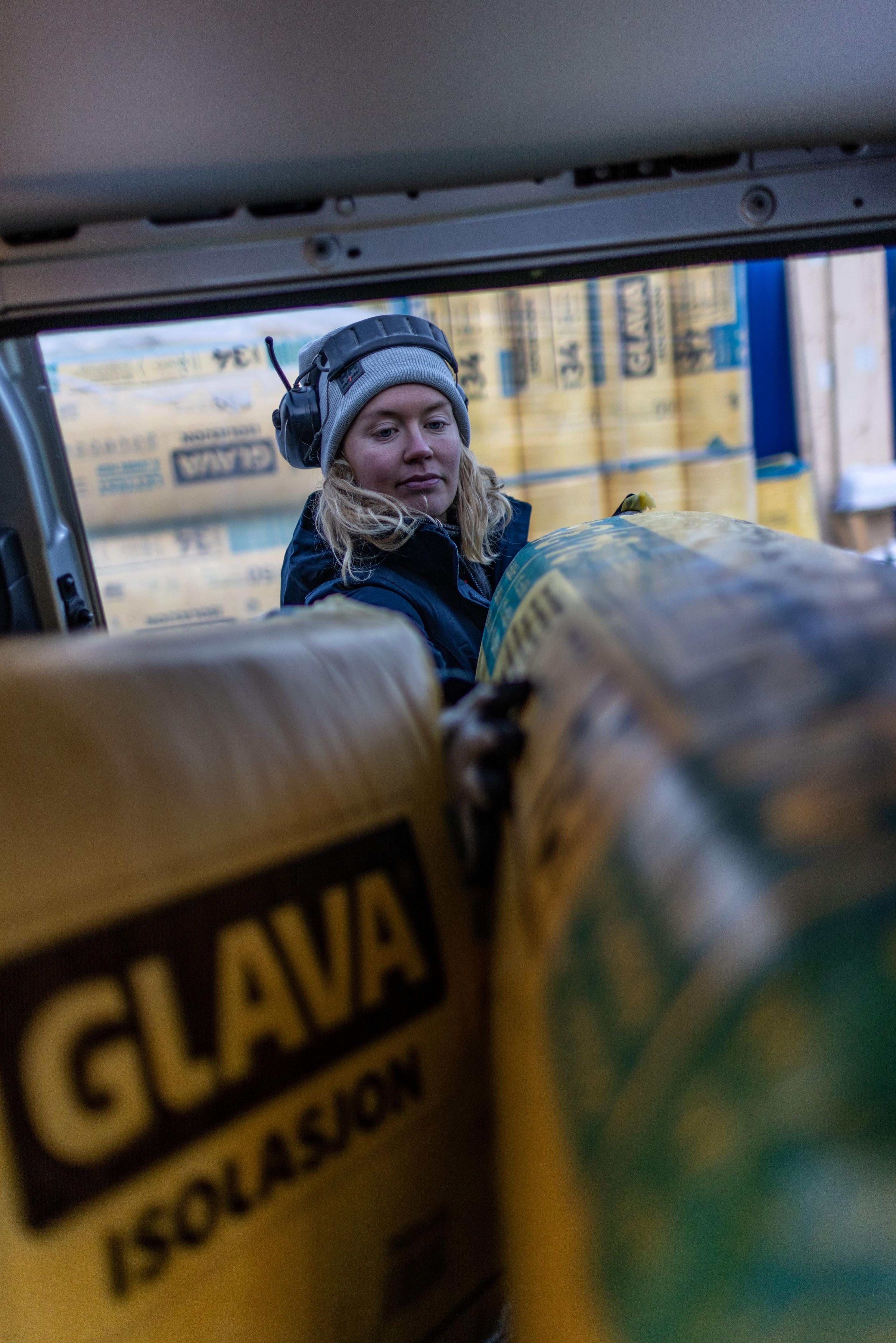 Dame som løfter inn Glava isolasjon i varebil