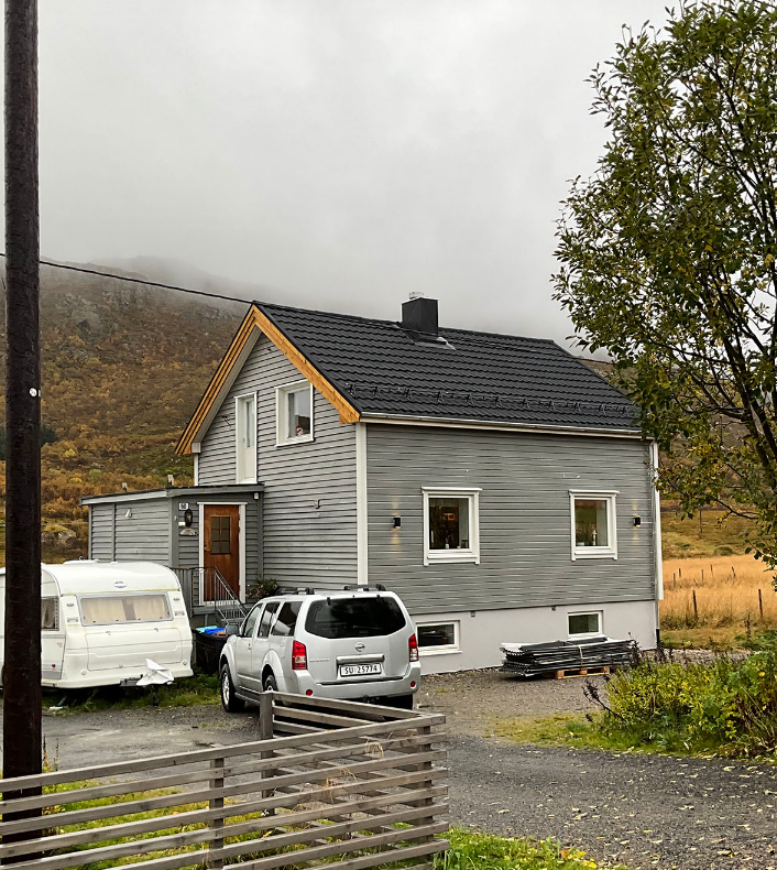 Bilde av et grått hus med sort tak