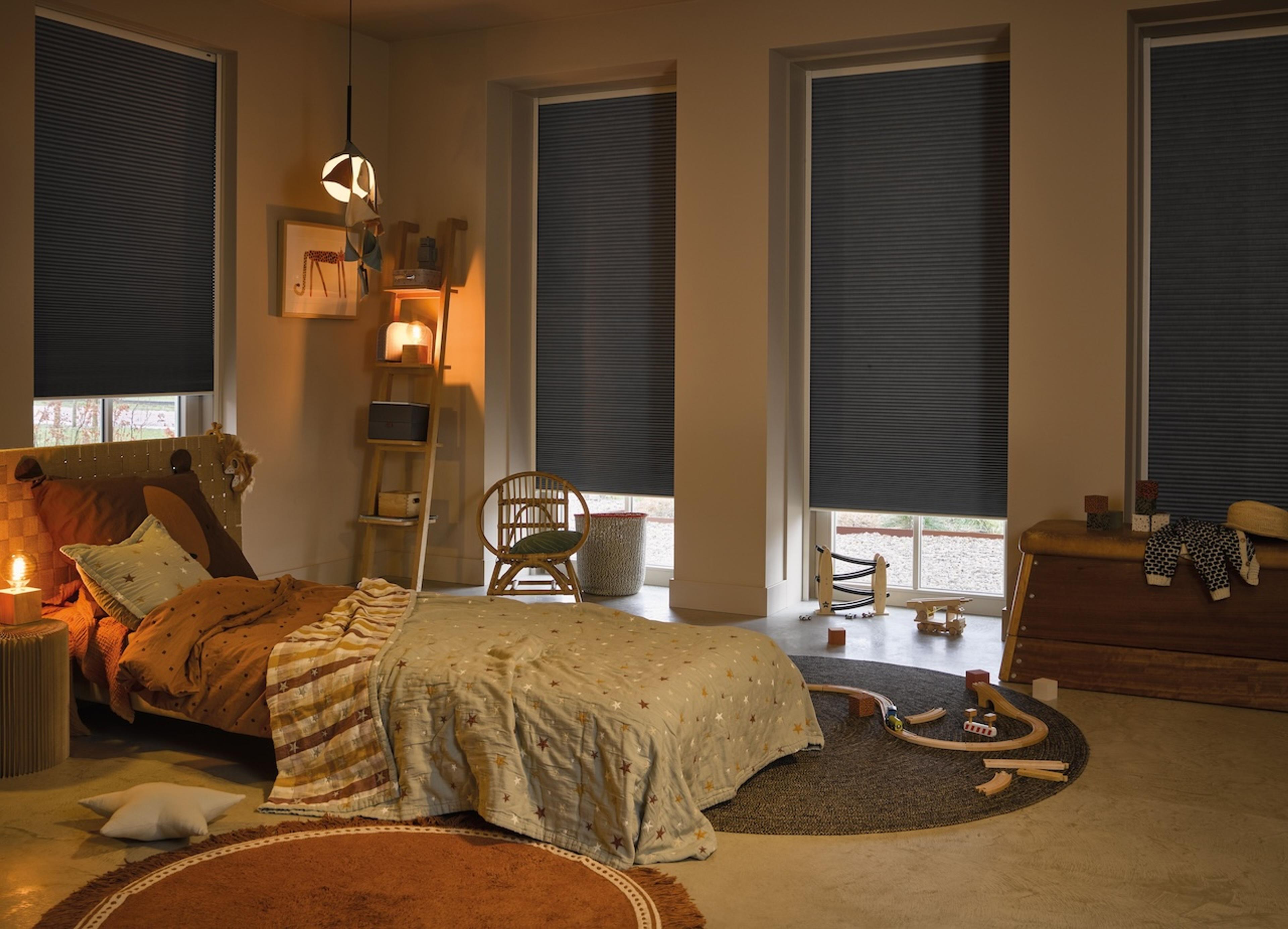 Mørkleggende og motoriserte Duette-gardiner er praktisk på soverommet.