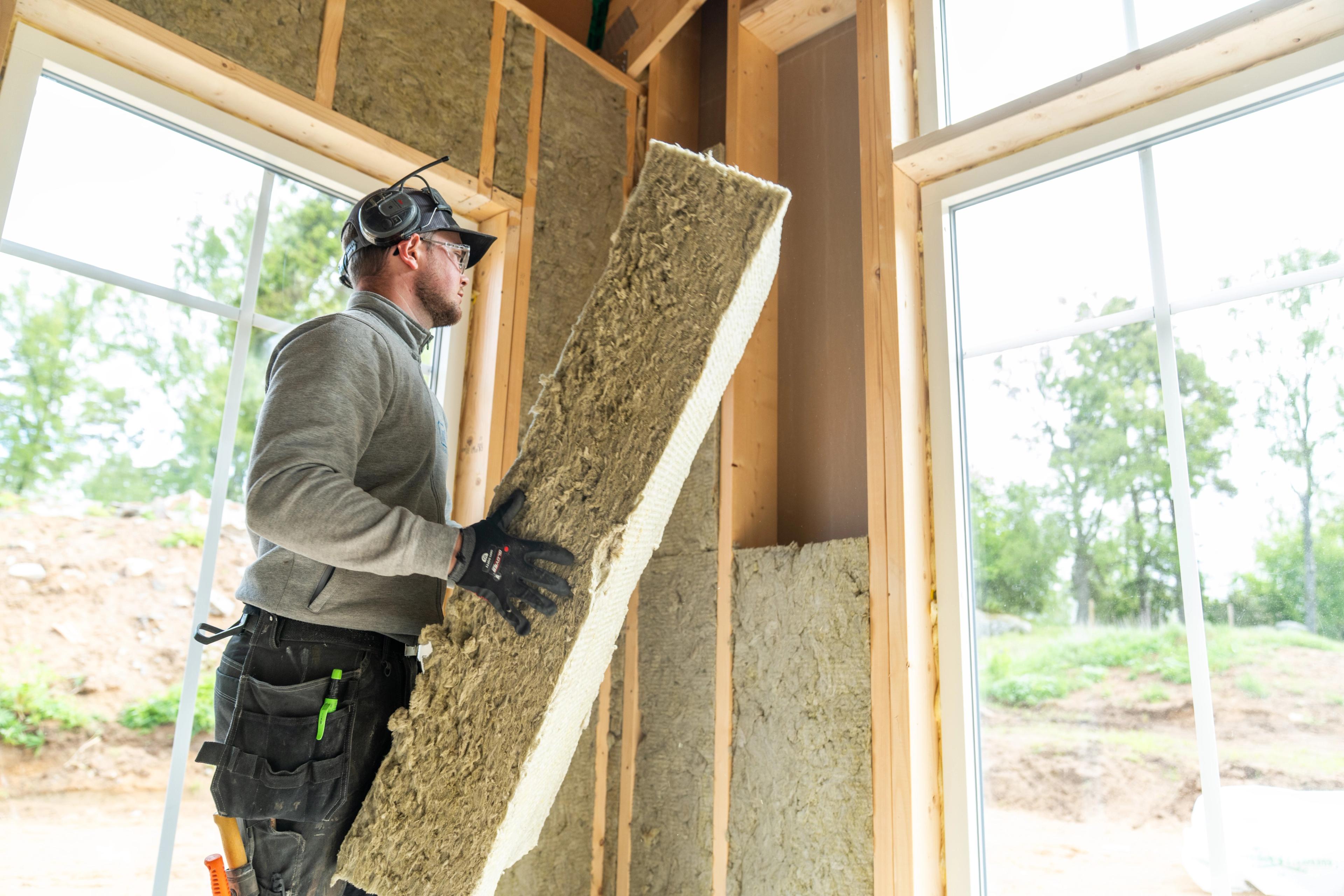 Håndverker som bærer trefiberisolasjon 