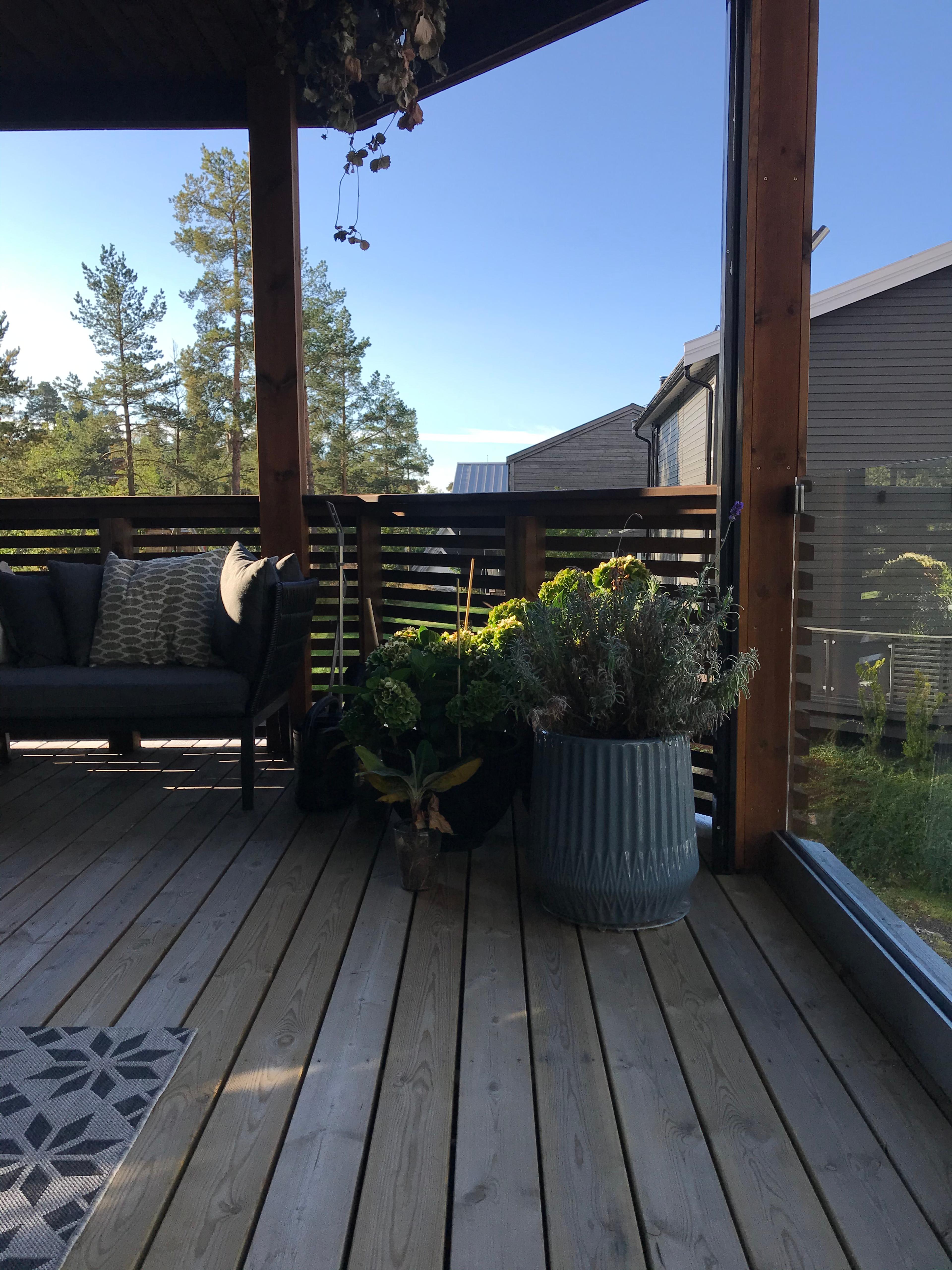 Terrassekombinasjon med rekkverk i glass og tre.