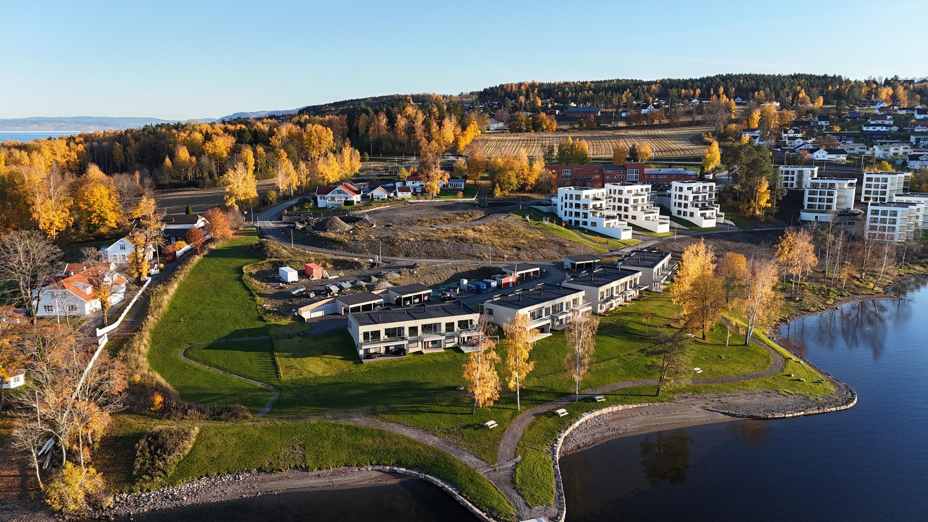 Oversiktsbilde over de tre blokkene med rekkehus som kommer opp like ved strandkanten til Mjøsa.