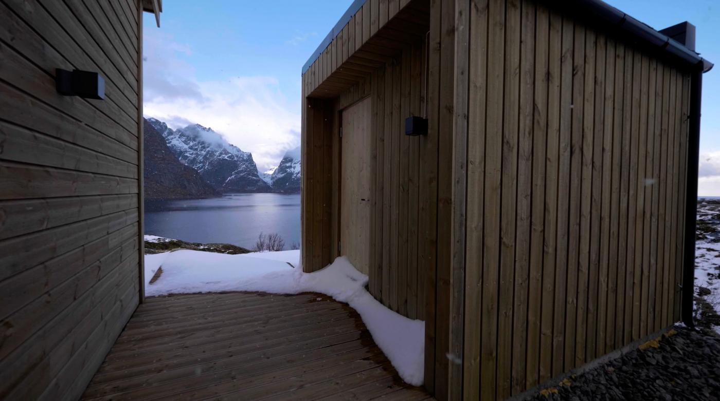 Utvendig badstue med hav og fjell i bakgrunnen