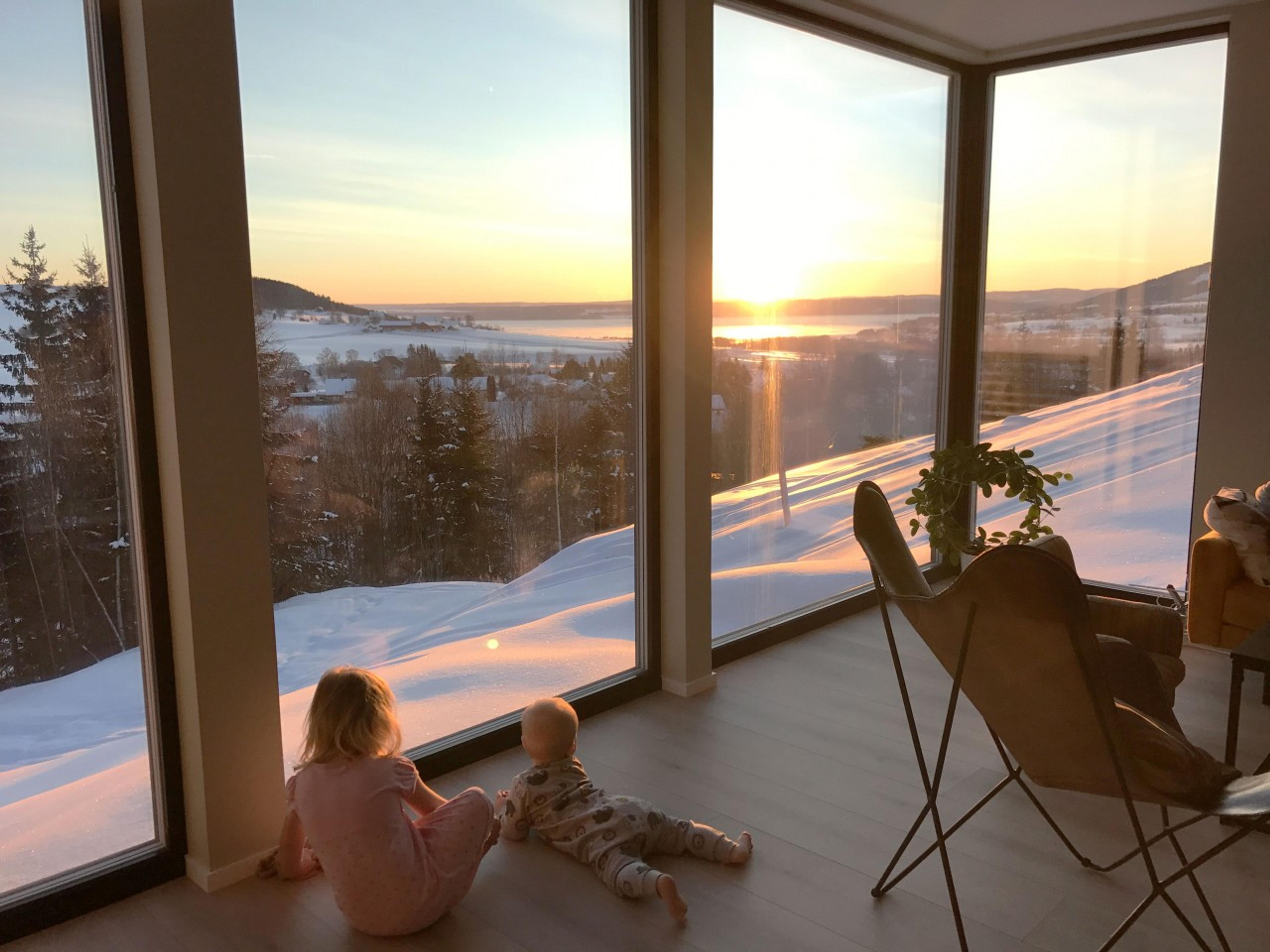 To barn som ser ut av stuevinduet