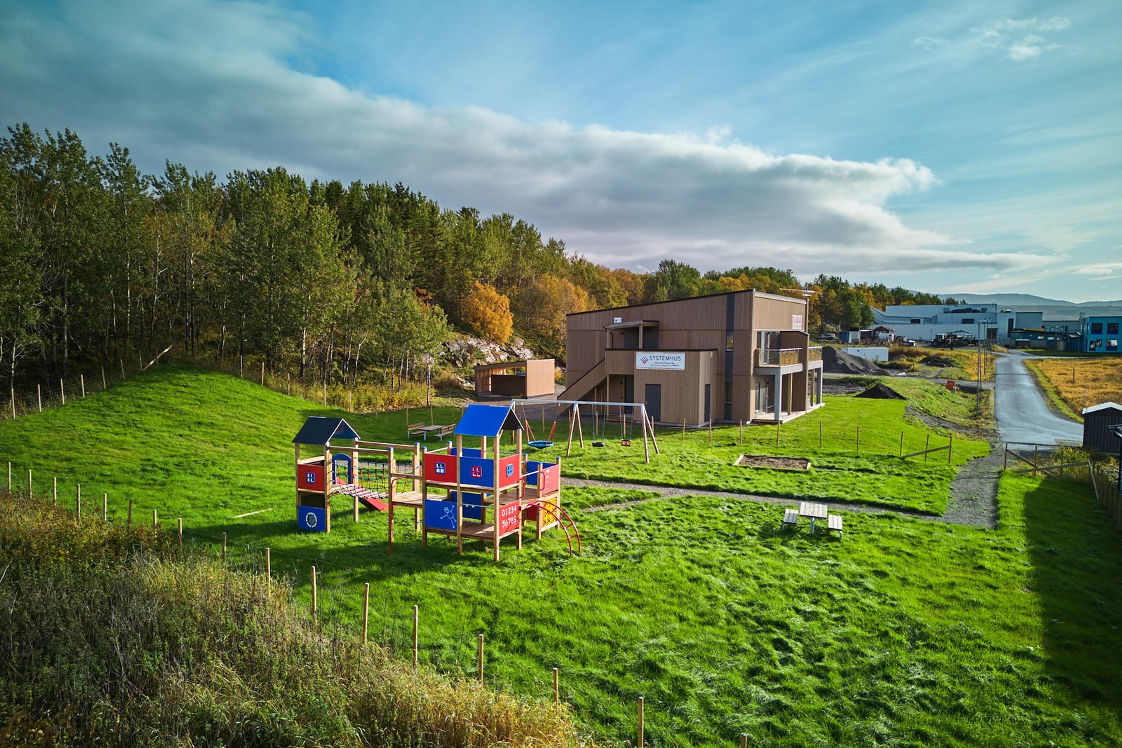 En lekeplass med gress og lekeapparat