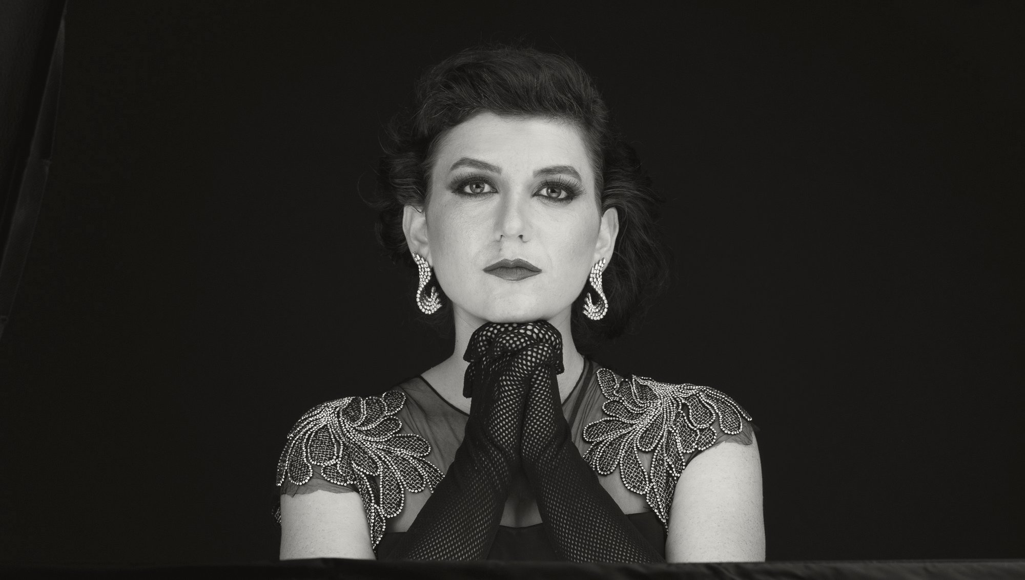 Yael Rasooly in a black-and-white portrait, wearing a glove near her chin.