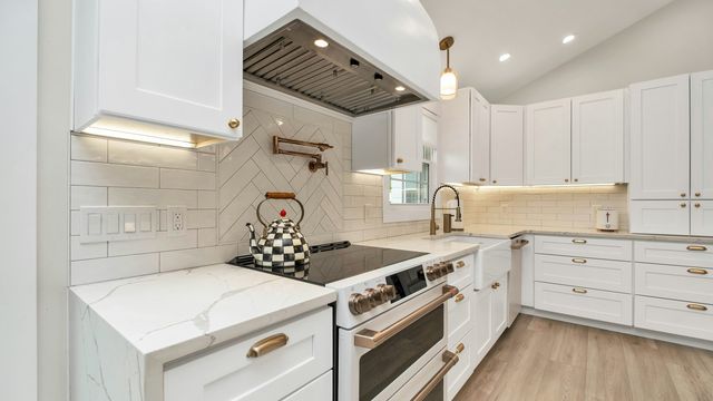 Bright white shaker kitchen with quartz countertops and gold hardware
