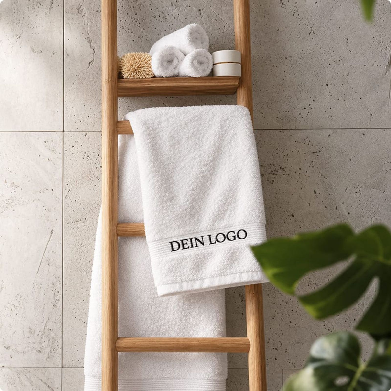 Photo d’une serviette de bain sur une échelle, avec un logo brodé