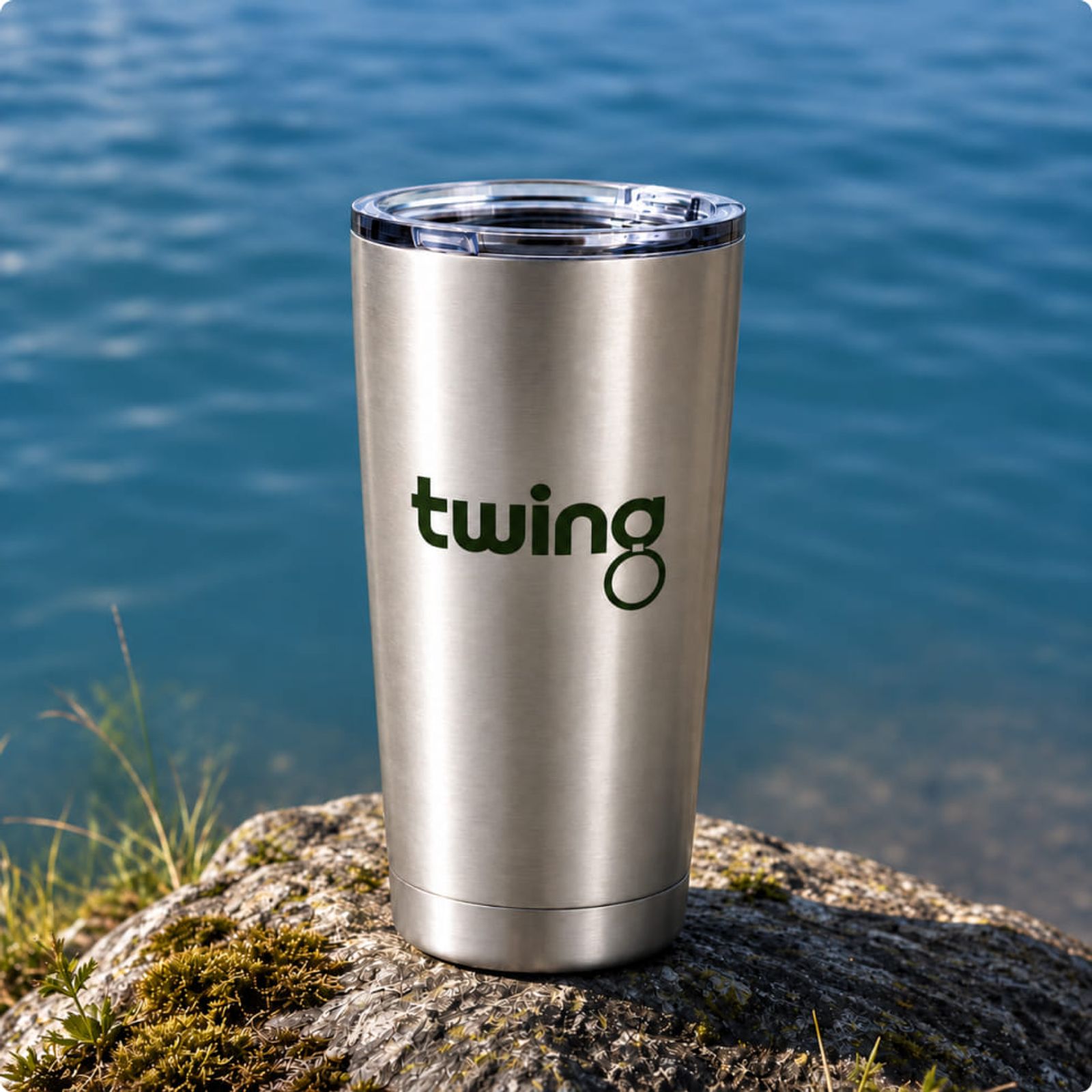 Edelstahl Thermobecher bedruckt von Twing mit Logo von Twing vor einem Bergsee