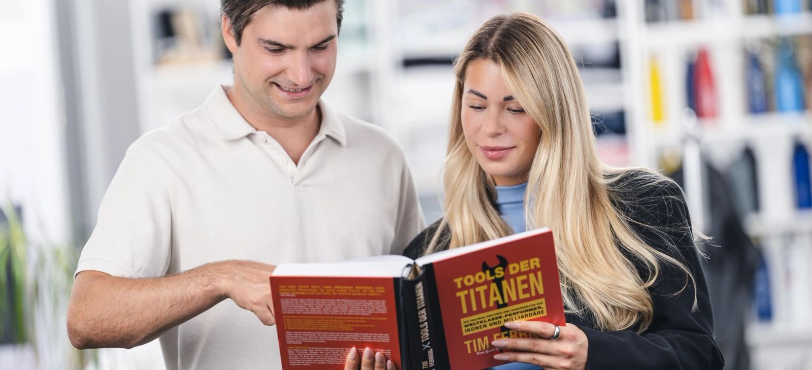Deux personnes regardent ensemble un livre qu’elles tiennent en main