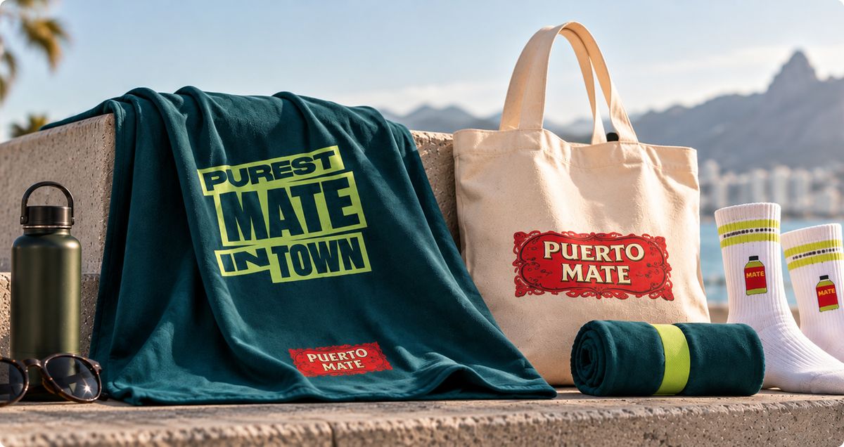 Merch für El Tony Mate und Puerto Mate: bedrucktes Badetuch, Jutebeutel und Socken am Meer
