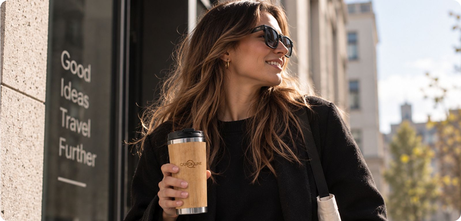 Une collaboratrice tient en main le mug isotherme Quickline en bambou