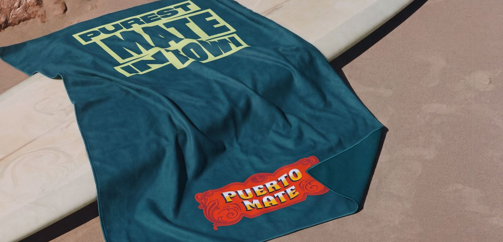 Badetuch «Purest Mate in Town» mit Puerto-Mate-Label auf einem Surfbrett