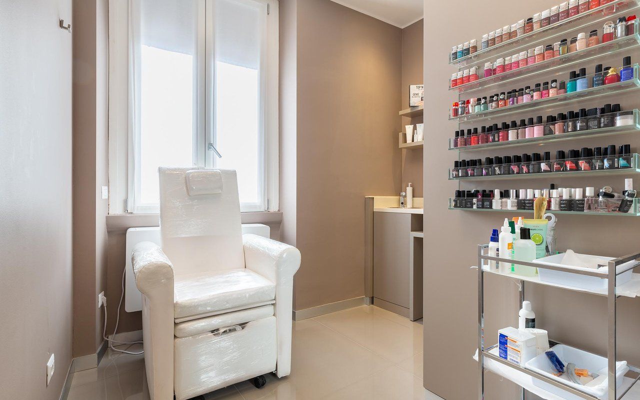 Postazione pedicure con parete di smalti