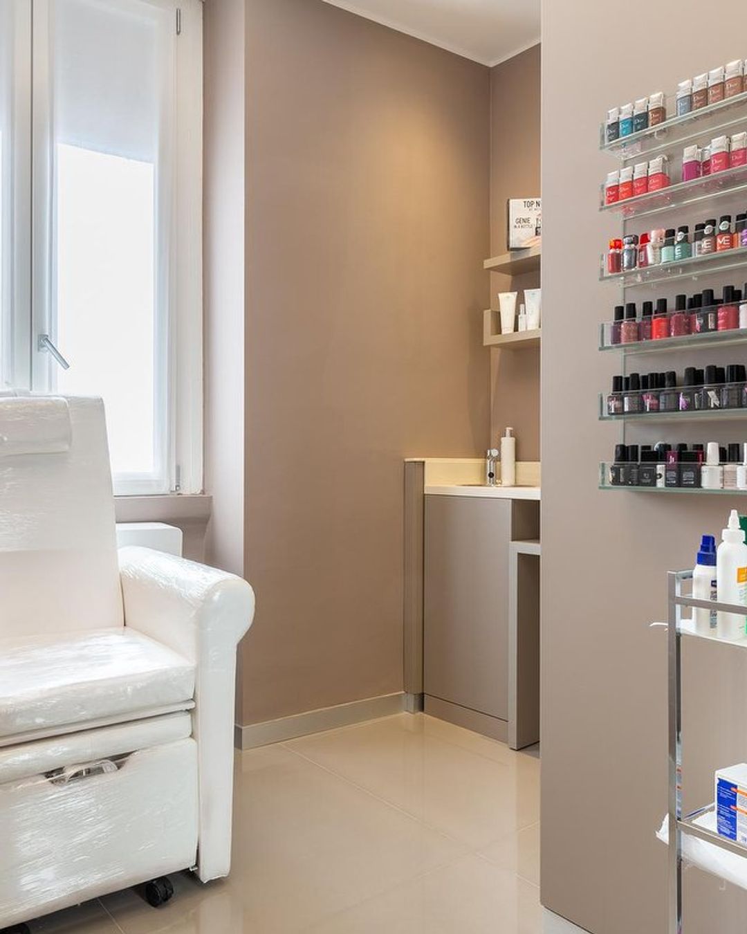 Postazione pedicure con parete di smalti