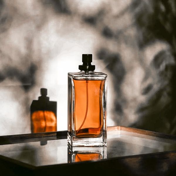 Un flacone di profumo ambrato su un ripiano a specchio