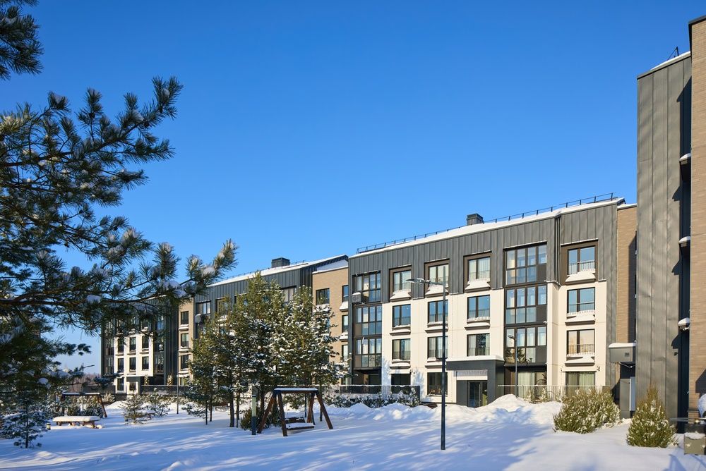 Modern apartment building exterior in Philadelphia during winter, showing snow-covered walkways and common areas used by tenants