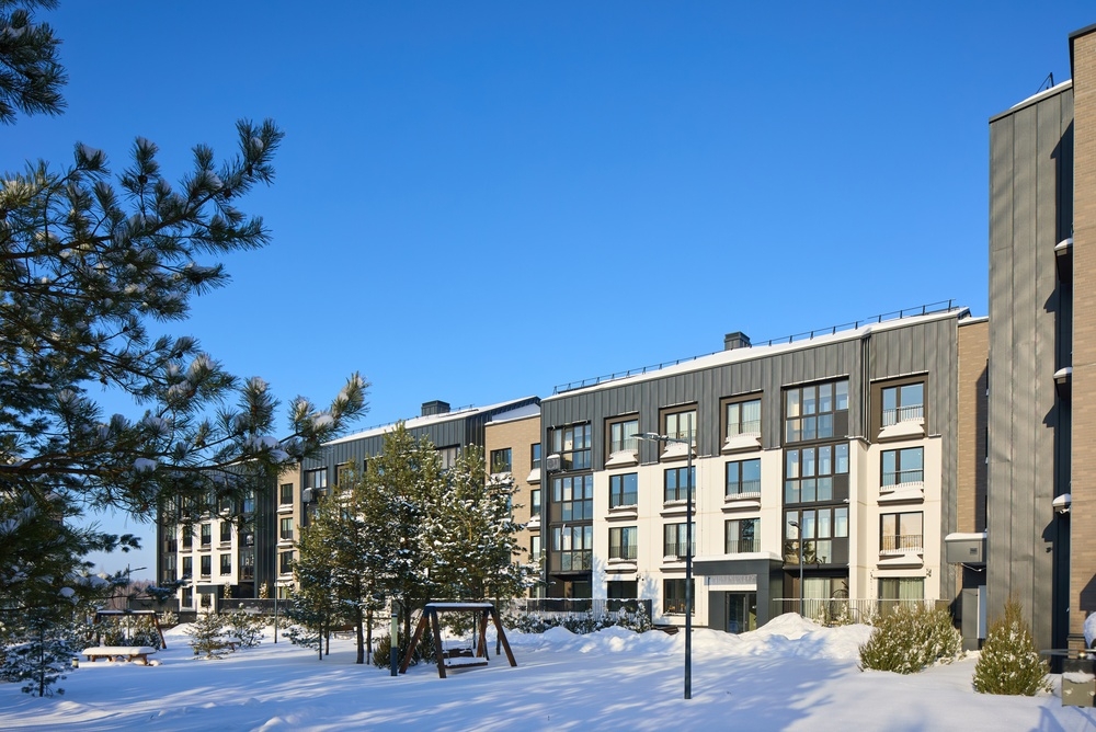 Image Modern apartment building exterior in Philadelphia during winter, showing snow-covered walkways and common areas used by tenants