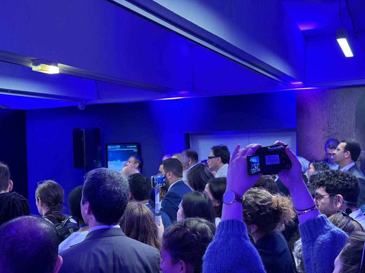 Public rassemblé devant la scène le jour du lancement, plusieurs personnes filment avec leur téléphone