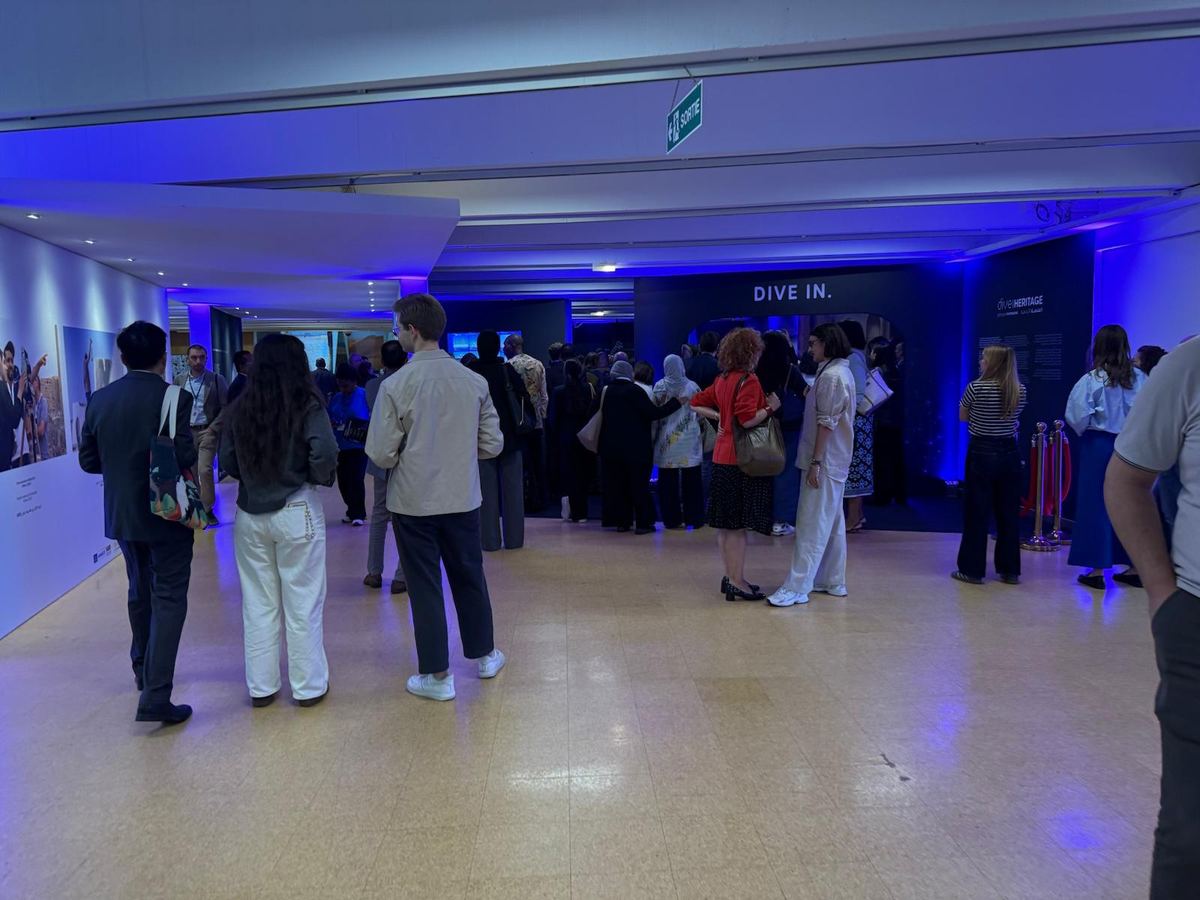 Visiteurs entrant dans l’exposition Dive into Heritage sous l’enseigne « DIVE IN »