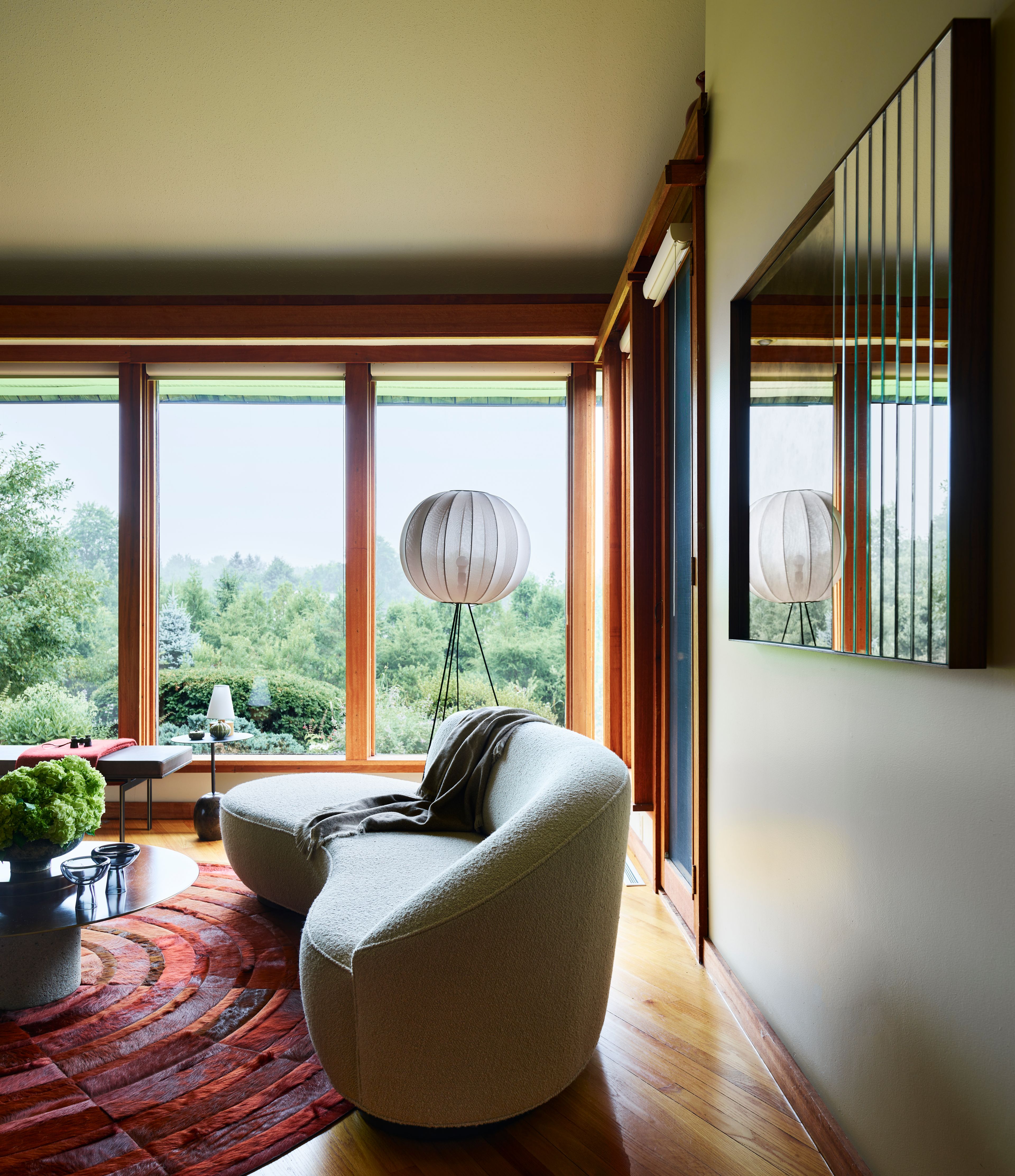 A living room with a couch and table. The room is designed with a dynamic layout, showcasing unobstructed views of the expansive landscape.