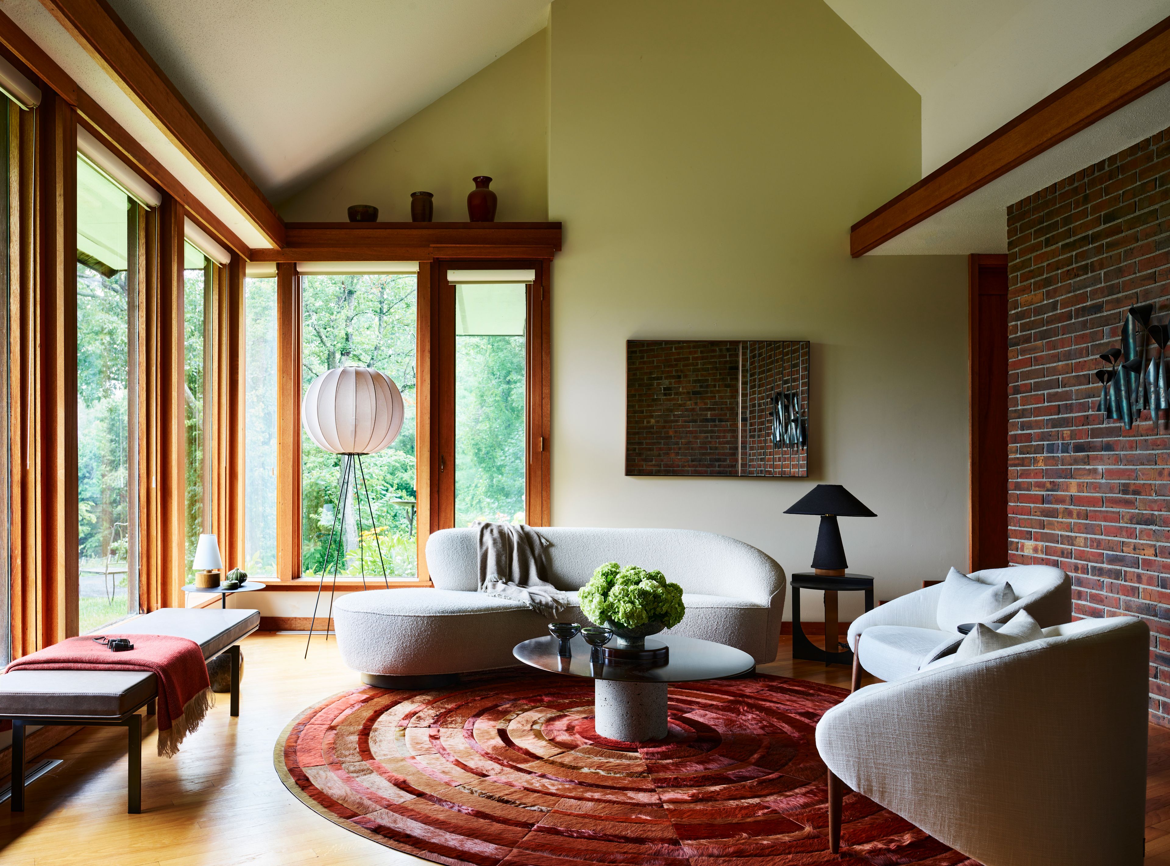 A living room with a red rug and white furniture. The room is designed with a dynamic layout, combining antique and contemporary furnishings.