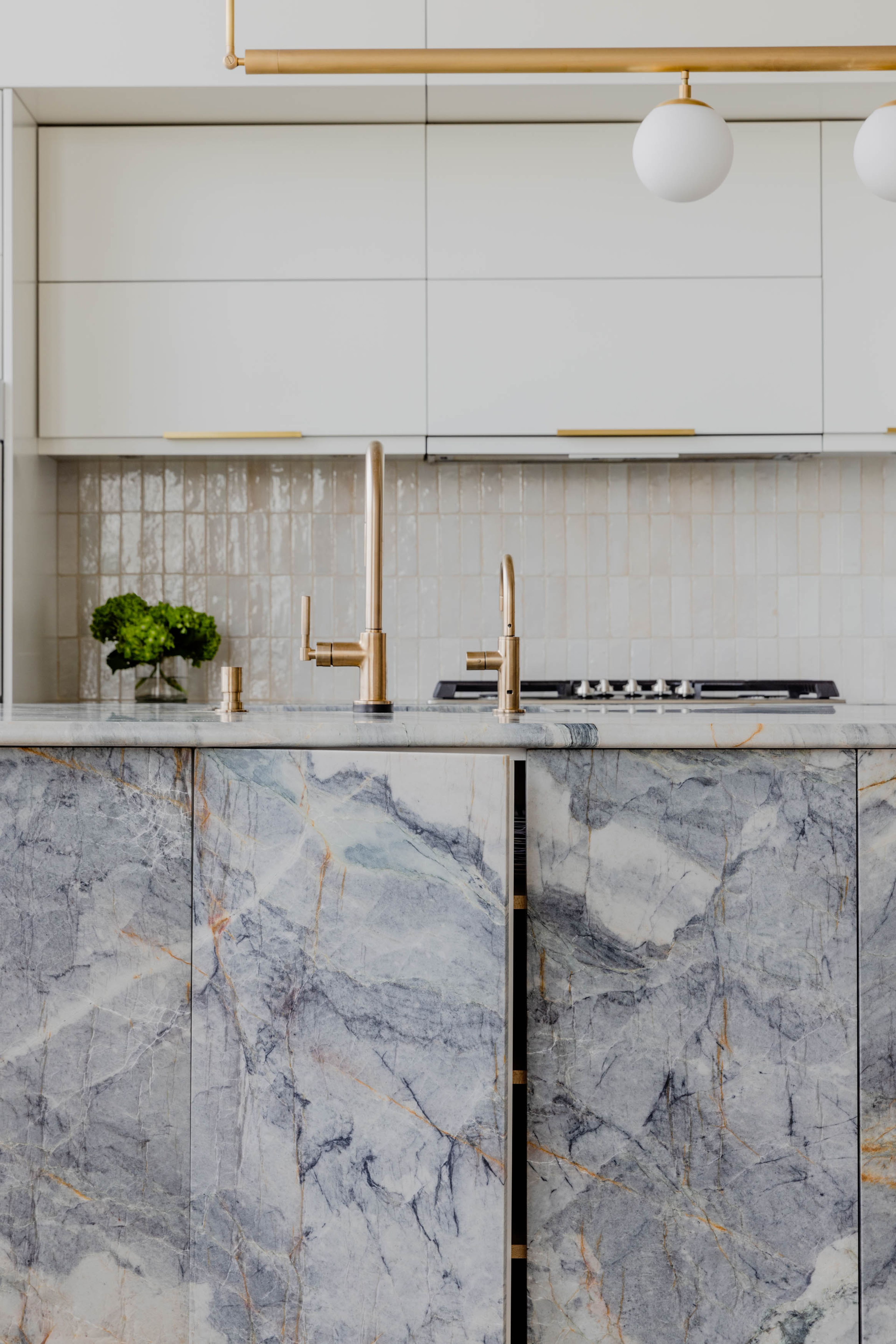 Close up view of the brass sink seated in the rounded stone island.