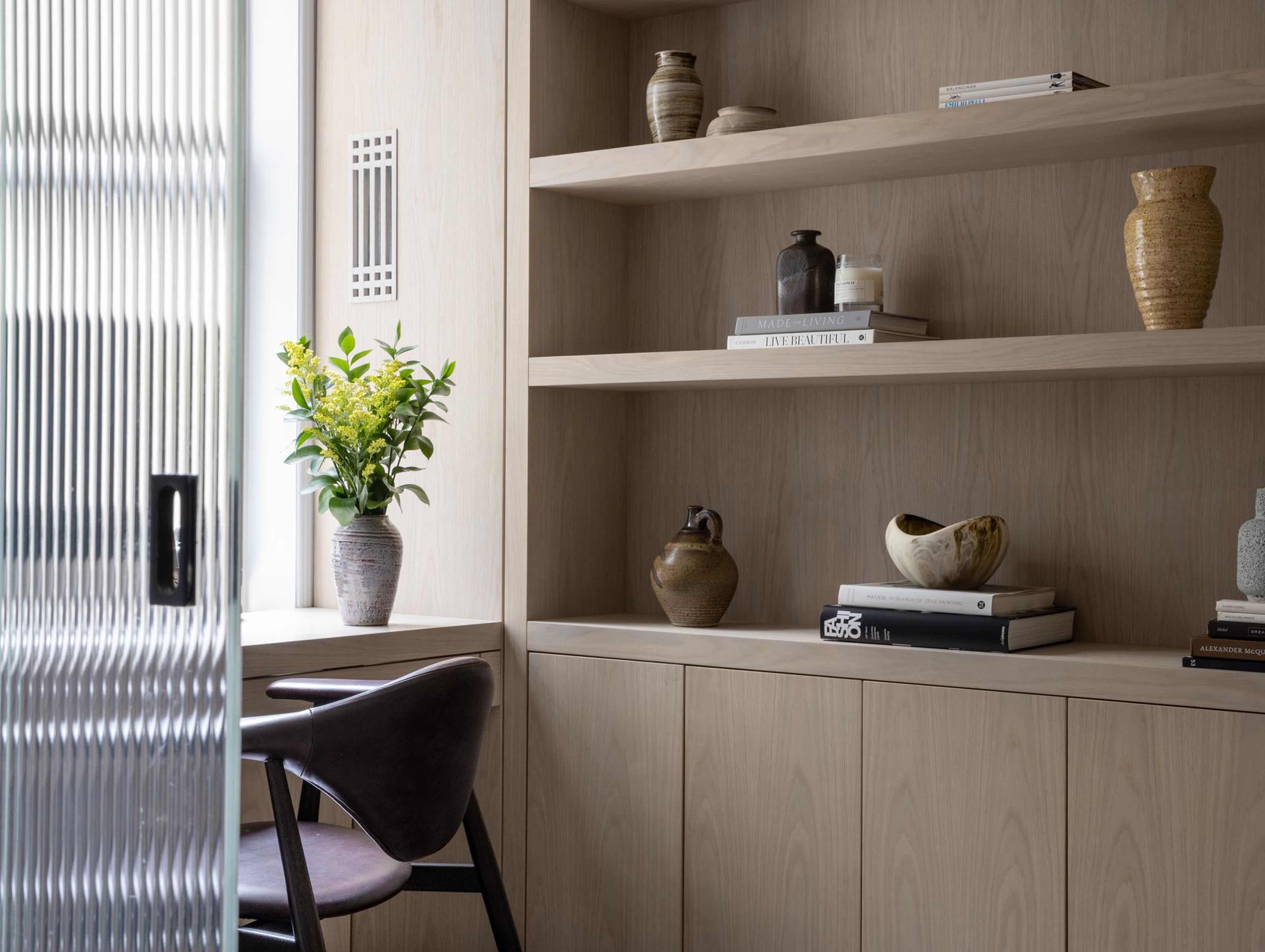 A puzzle of structural integration and layout restructuring. Relocated kitchen, custom metal panels, aubergine silk wallcoverings, wood millwork, stone paneling, fluted glass doors for natural light and acoustic separation.