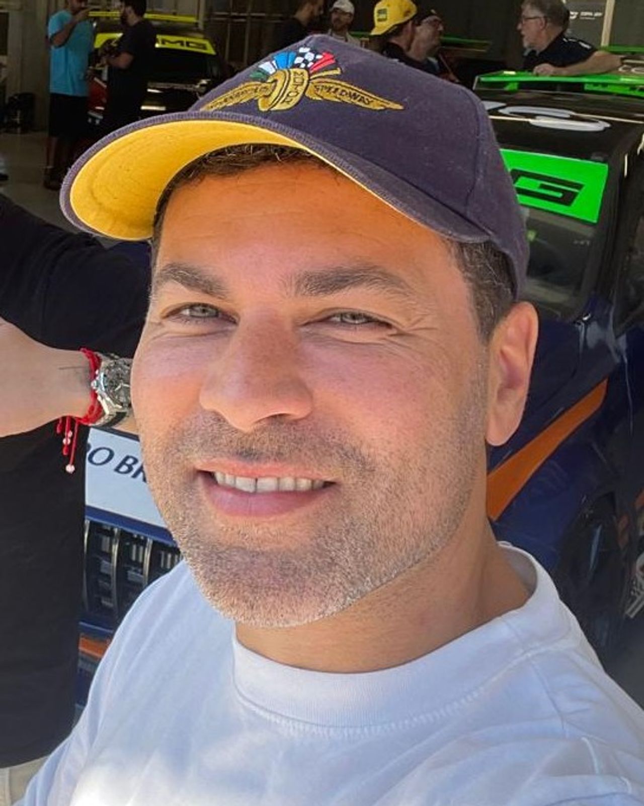 Retrato de Kleber Bertoldo, sorrindo, de boné e camiseta branca
