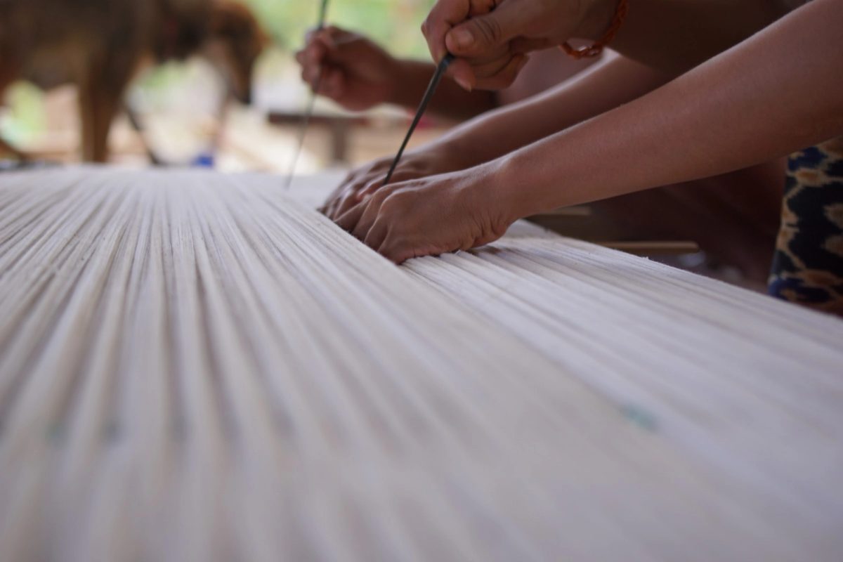Hands marking the divisions on stretched cotton threads