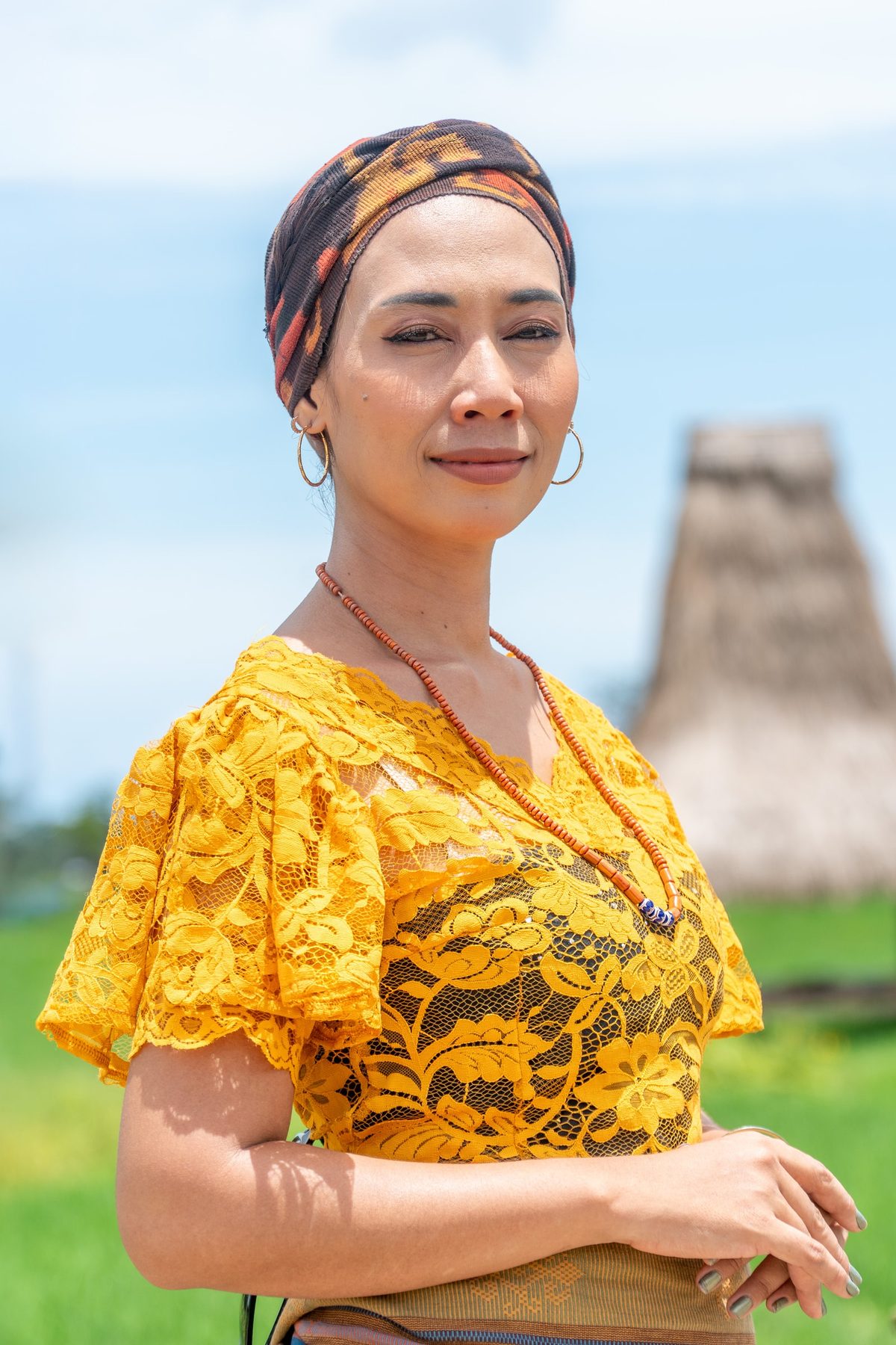 Portrait of Nensi wearing Ikat and a yellow lace blouse