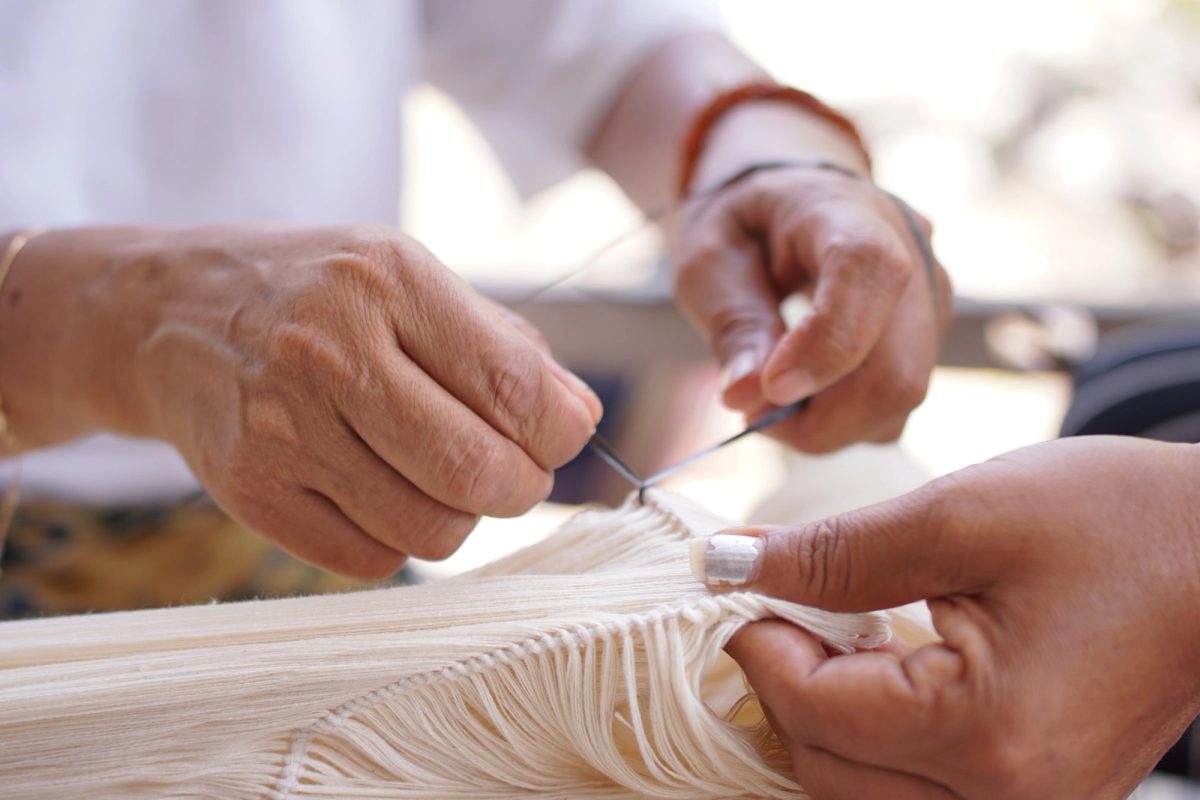 Hands tying and separating layers of cotton yarn
