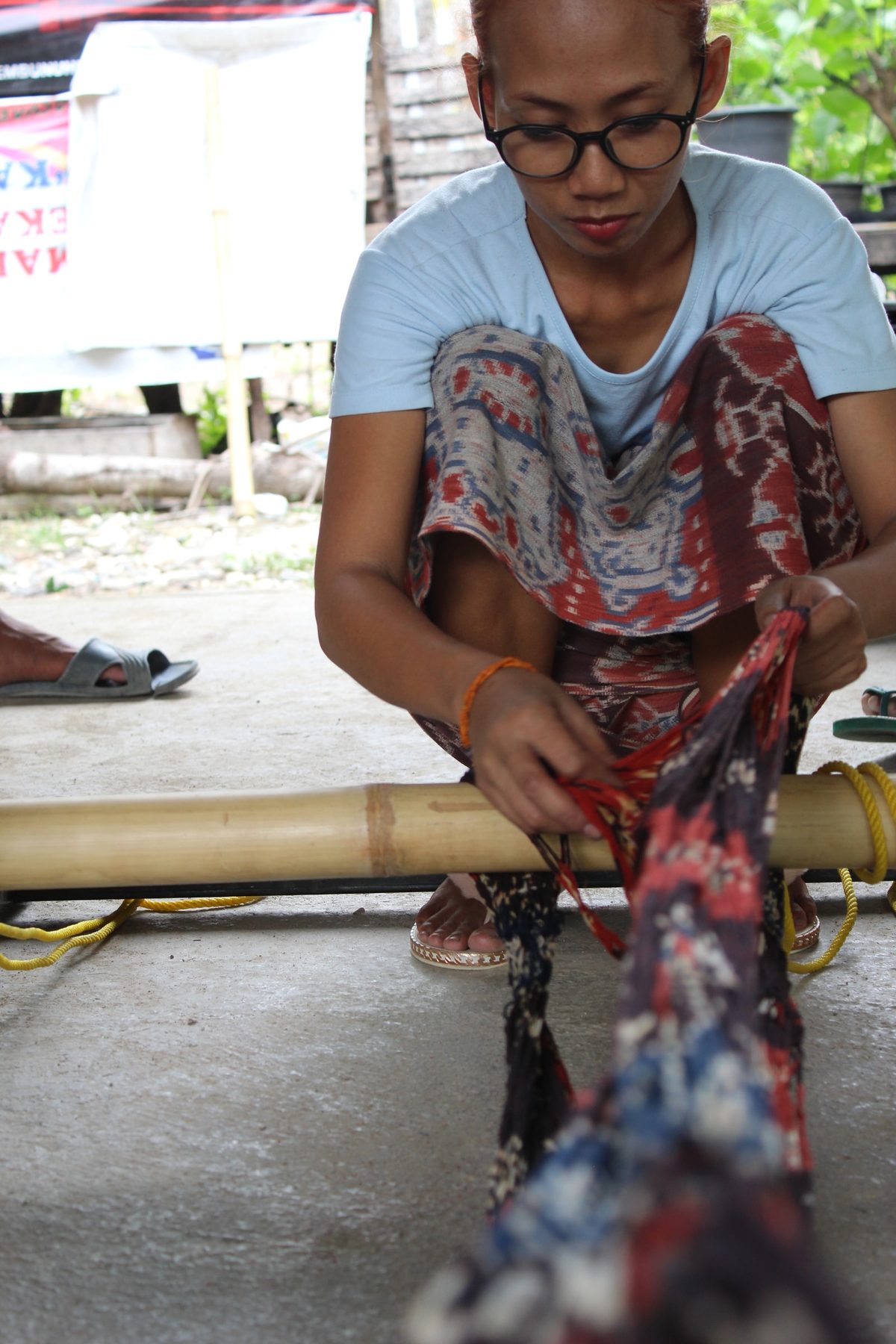 A woman separating layers of dyed Ikat threads