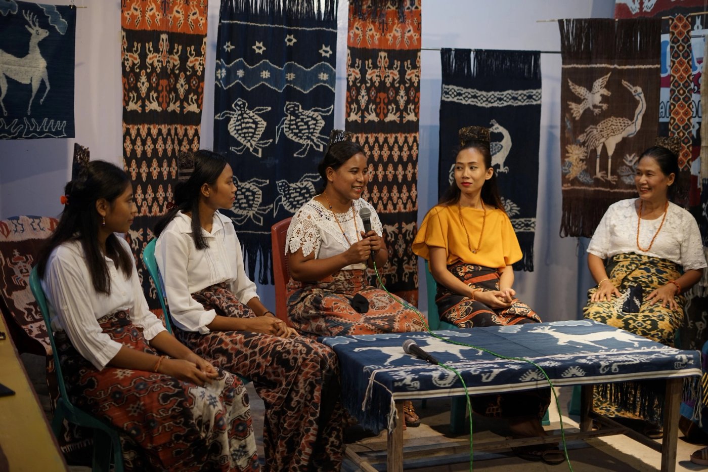 Women sharing stories surrounded by Sumbanese ikat textiles
