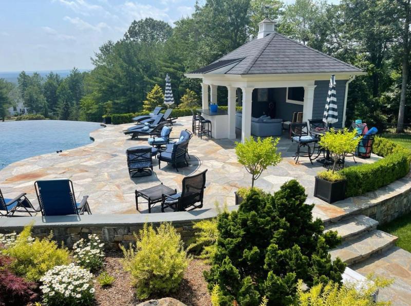Infinity edge pool with flagstone patio, cabana, and panoramic hilltop views
