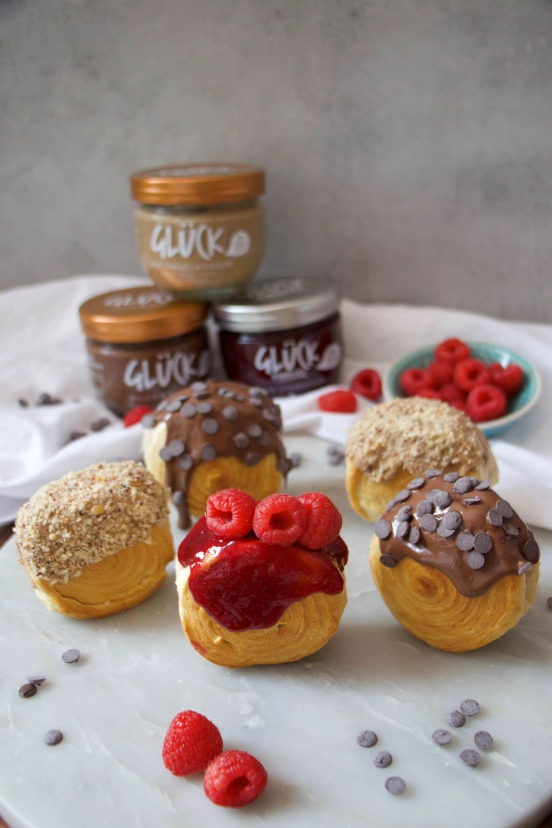 New York Rolls garniert mit Himbeeren, Schokosauce und Haselnusssauce.