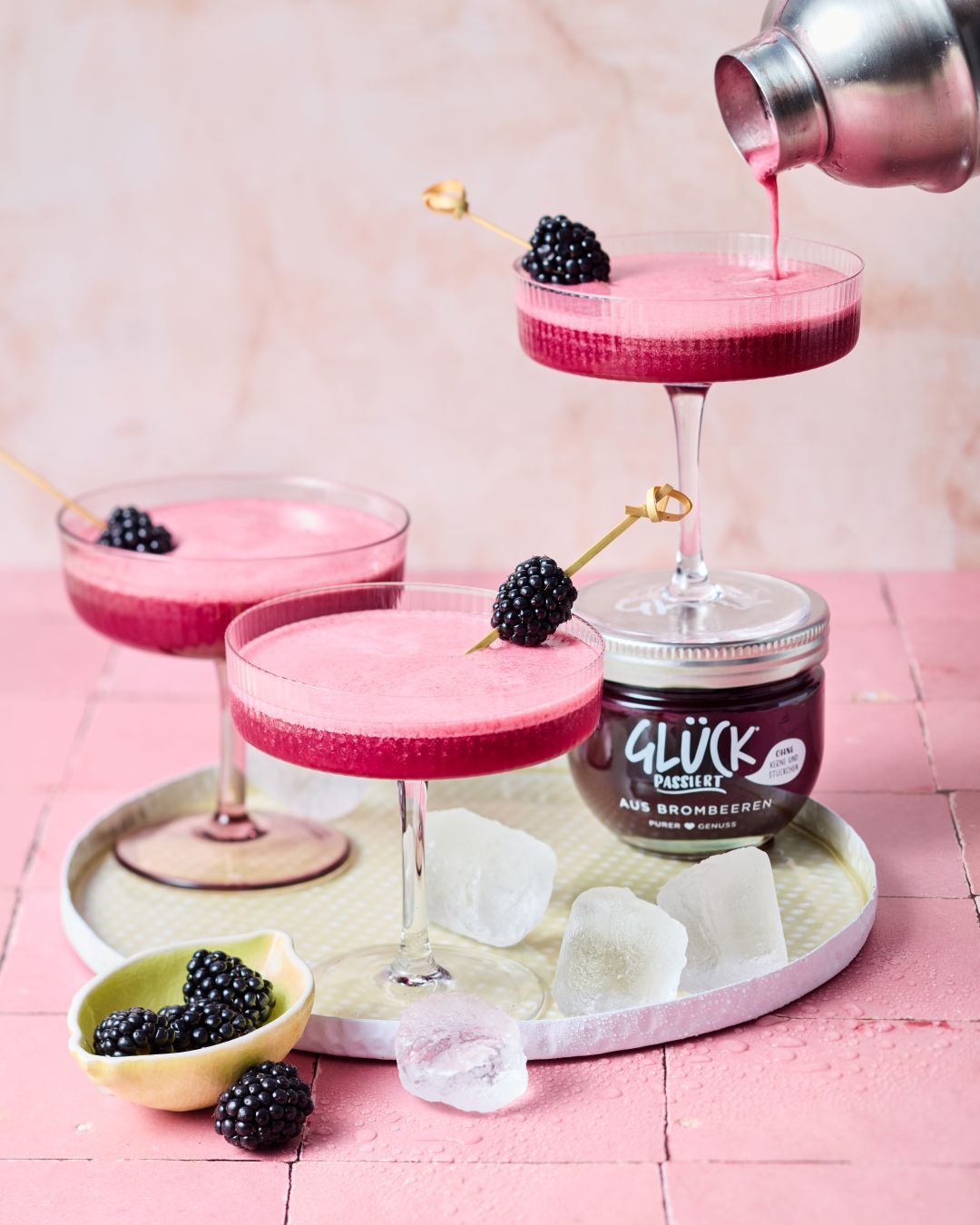 Brombeer Sour mit GLÜCK passiert aus Brombeeren im Glas, garniert mit frischen Brombeeren und Eiswürfeln.