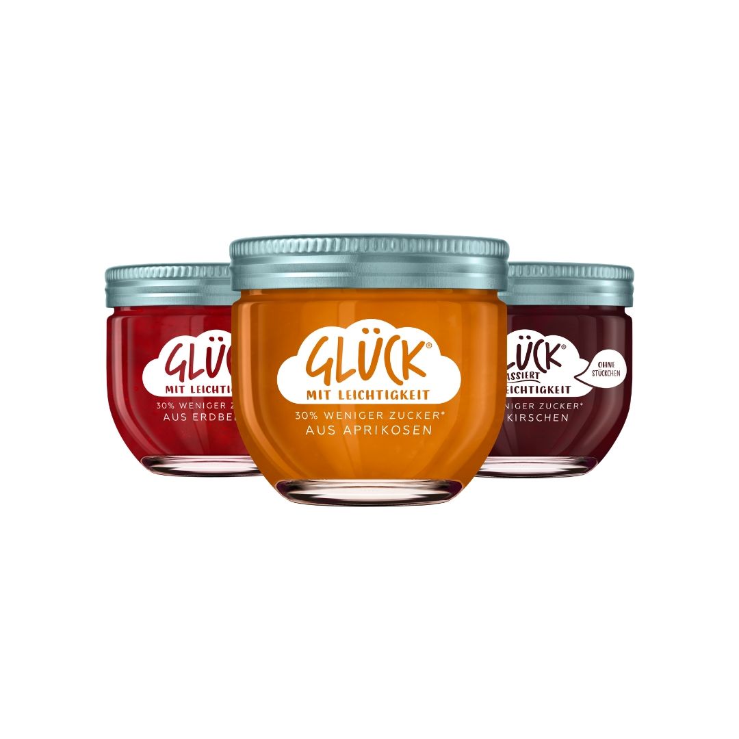 Zu sehen sind drei Sorten der GLÜCK Range mit Leichtigkeit: GLÜCK mit Leichtigkeit aus Aprikosen, GLÜCK passiert mit Leichtigkeit aus Schwarzkirschen und GLÜCK mit Leichtigkeit aus Erdbeeren.
