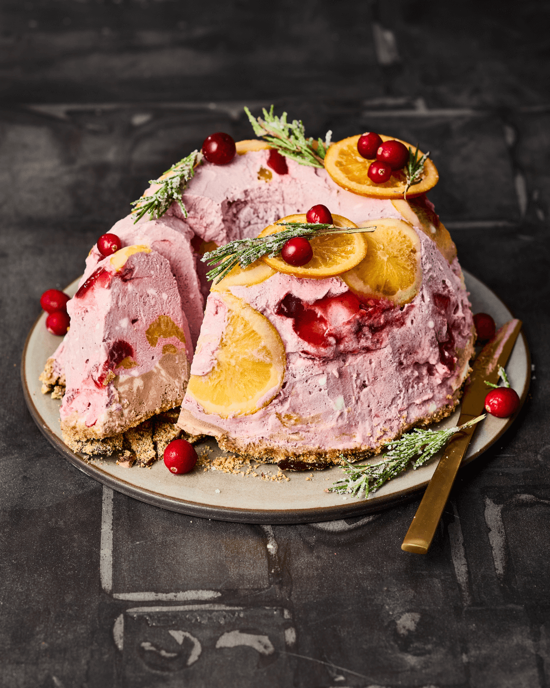Punch-Parfait-Gugelhupf mit rosa Creme und winterlichen Früchten auf einem Teller