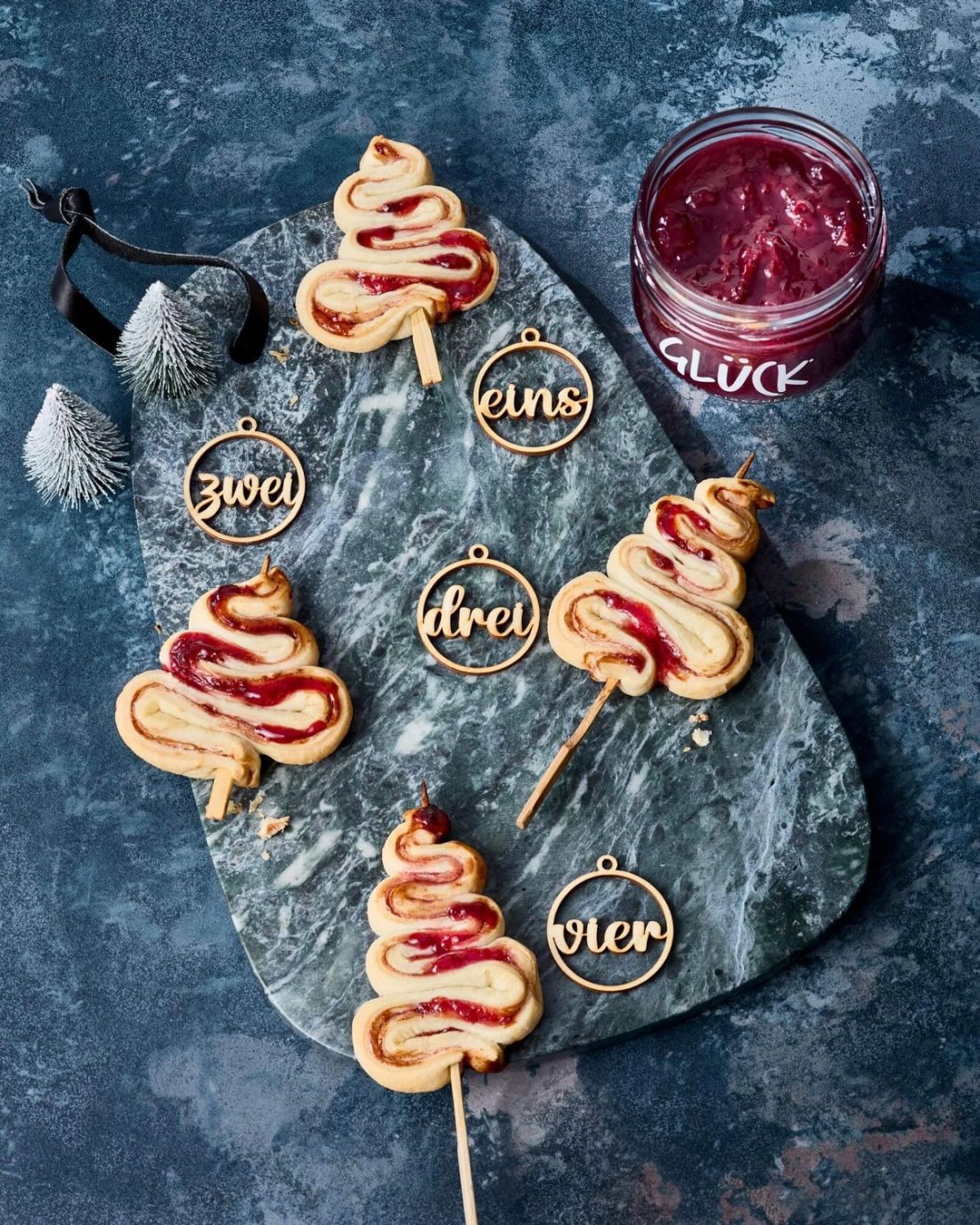 Kirschbäumchen on a stick mit Weihnachtsdeko. Daneben ein Glas GLÜCK aus Kirschen.