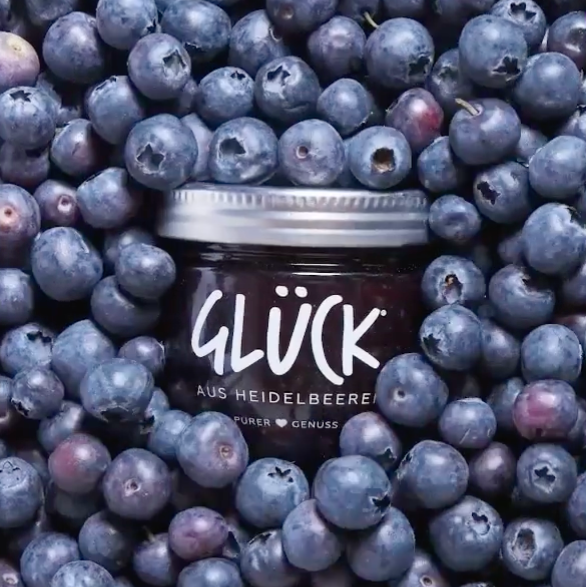 Video von den GLÜCK Sorten GLÜCK aus Heidelbeeren, GLÜCK aus Aprikosen, GLÜCK aus Rhabarber und GLÜCK passiert aus Brombeeren, die zunächst vollflächig von den Früchten der jeweiligen Sorte bedeckt sind und dann hervorkommen.